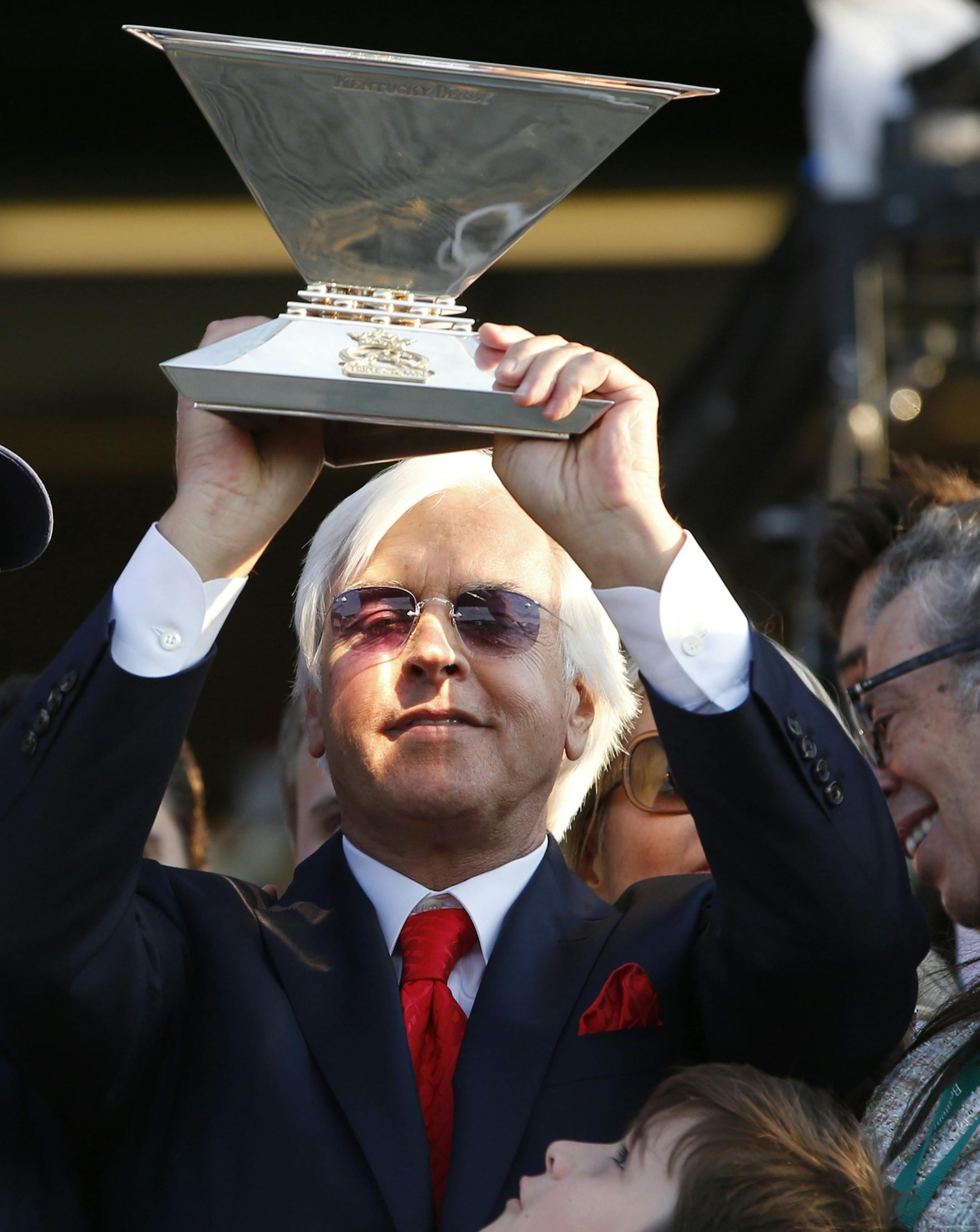 Trainer Bob Baffert holds up the Triple Crown Trophy with his son, Bode, after American Pharoah won the 147th running of the Belmont Stakes horse race at Belmont Park, Saturday, June 6, 2015, in Elmont, N.Y. (AP Photo/Kathy Willens)