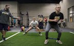 Strength and conditioning coach Josh Anderson, left, coached soccer player Devin Breeggemann (CQ) and basketball player Courtney Freeberg, right, in a