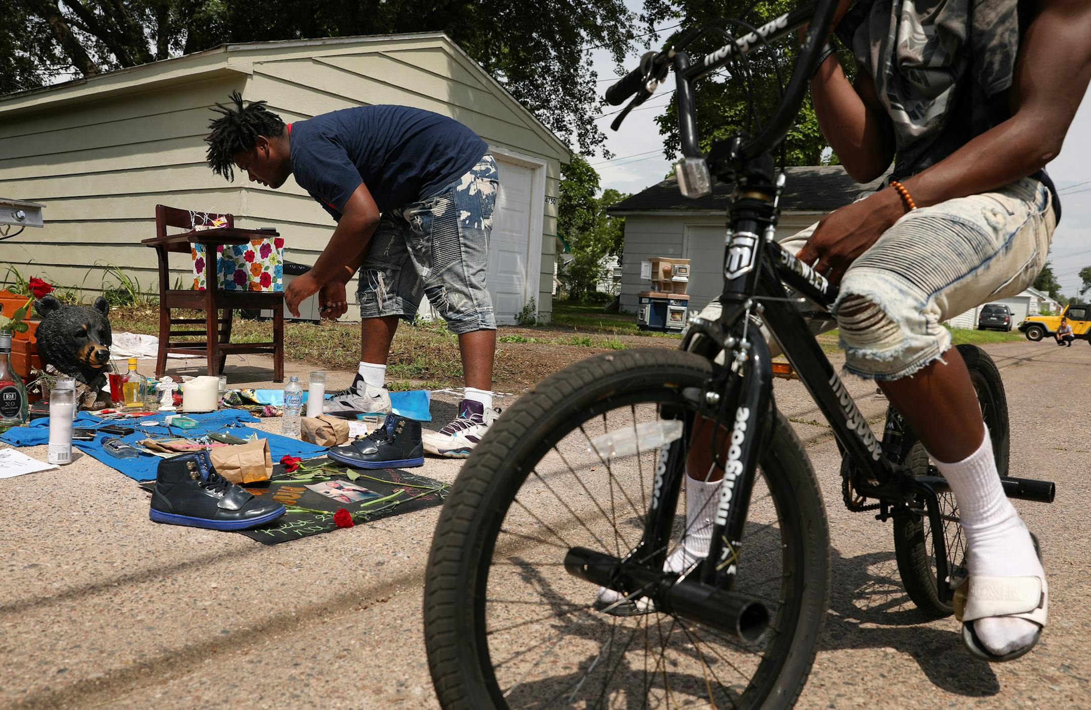 Nahaj Myles, 15, tended to a memorial set up in the alley where Thurman Blevins was killed by a Minneapolis police officer earlier in the week. Friends and community members gathered around a memorial in the alley where Thurman Blevins was killed by a Minneapolis police officer earlier in the week, Monday, June 25, 2018 in north Minneapolis.