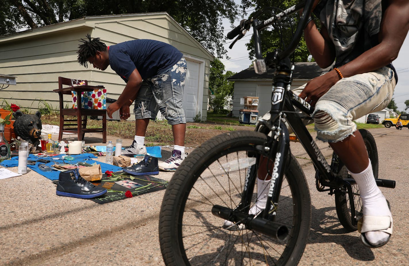 Nahaj Myles, 15, tended to a memorial set up in the alley where Thurman Blevins was killed by a Minneapolis police officer earlier in the week. Friends and community members gathered around a memorial in the alley where Thurman Blevins was killed by a Minneapolis police officer earlier in the week, Monday, June 25, 2018 in north Minneapolis.