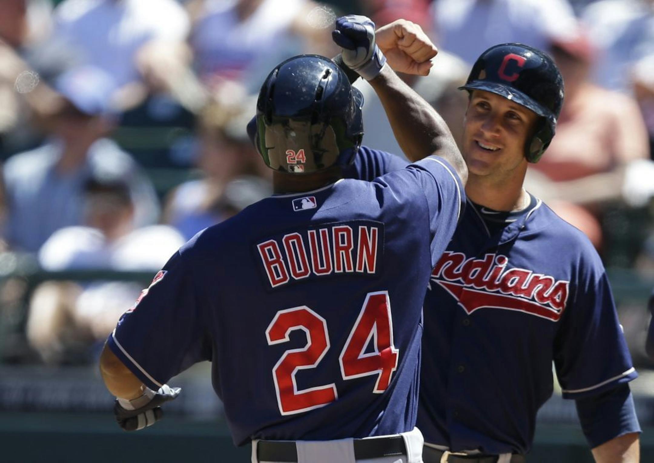Cleveland Indians' Michael Bourn (24) is greeted by Drew Stubbs, right, after Bourn hit a grand slam against the Seattle Mariners in the fifth inning of a baseball game, Wednesday, July 24, 2013, in Seattle.