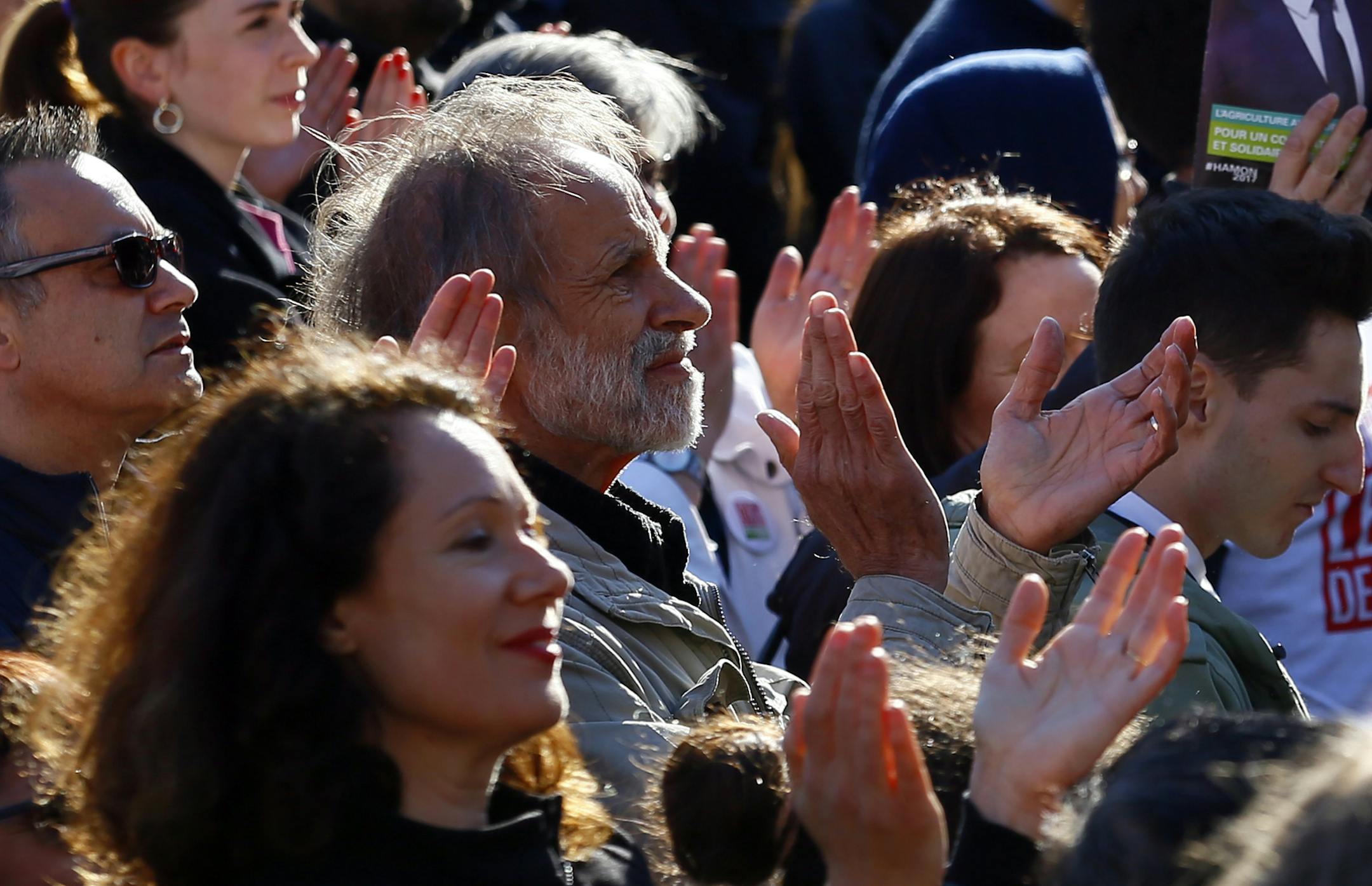 Supporters with a leaflet of French Socialist presidential candidate Benoit Hamon applause during a last-ditch rally and concert in Paris, Wednesday, April 19, 2017. Hamon is polling a distant fifth place ahead of Sunday's first-round election and has little chance of reaching the decisive May 7 runoff. (AP Photo/Francois Mori)
