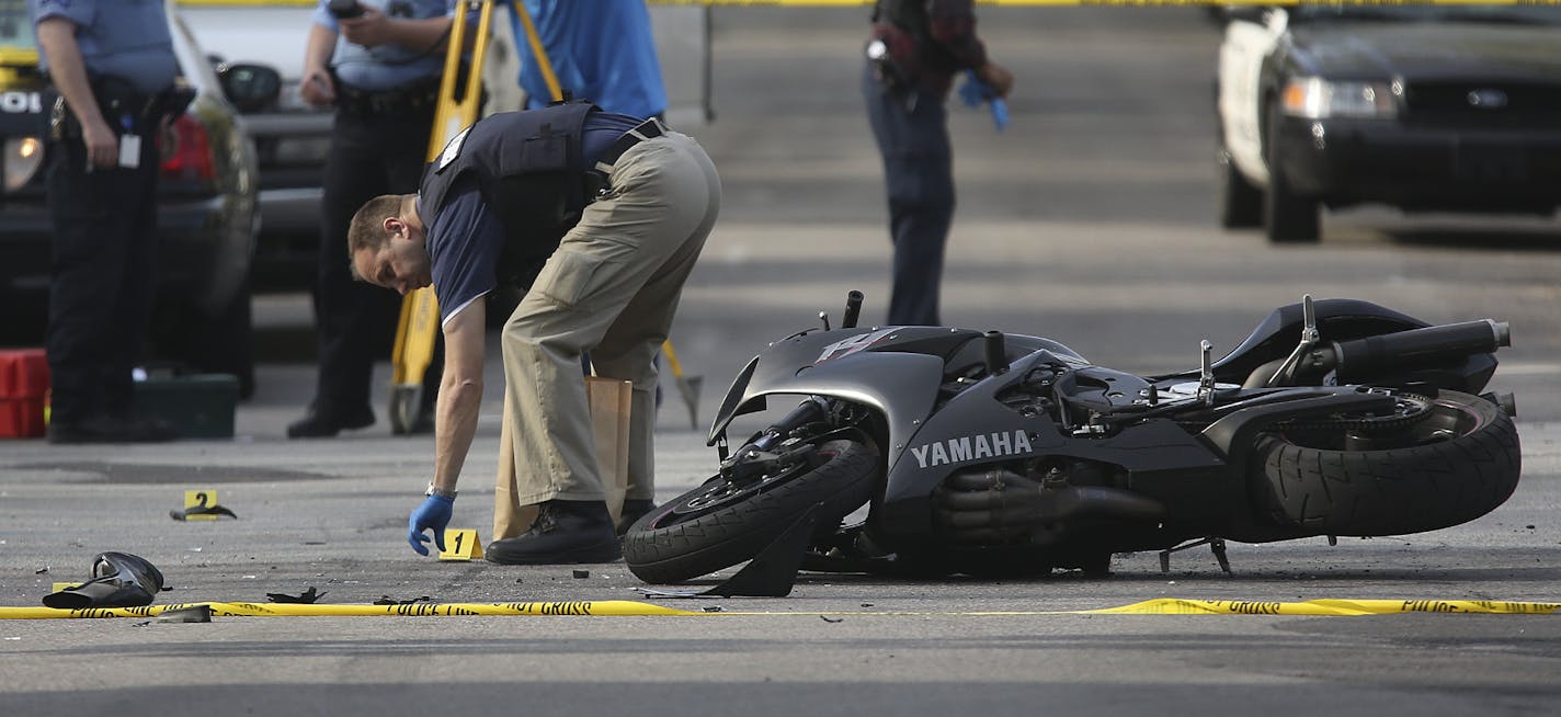 Minneapolis police officers surveyed the scene where a police vehicle and motorcycle collided at the intersection of Blaisdell and 26th in Minneapolis, Min., Friday, May 10, 2013.