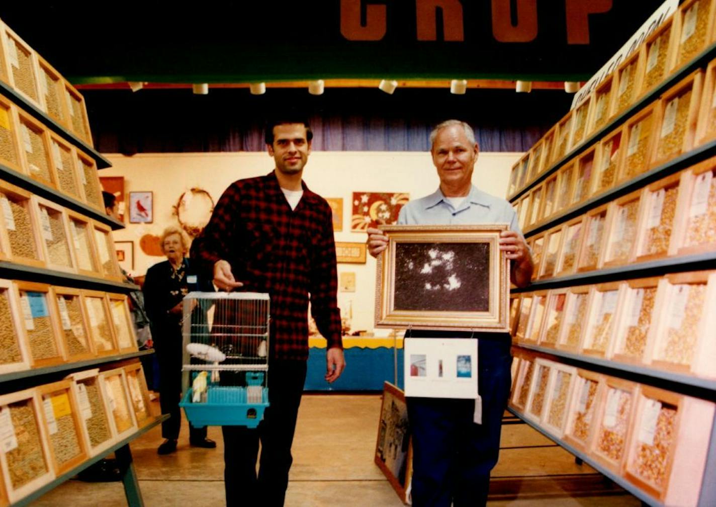 August 30, 1994 Crop art display at state fair bans art by bird Duane Smith, (right) holds the framed seedart created by Tweety Canary, (in cage, - left) which he disqualified from the State Fair 'Crop Art' Exhibit at the Agriculture/Horticulture bldg,-holding Tweety is Randy Buck. August 31, 1994 Tom Sweeney, Minneapolis Star Tribune