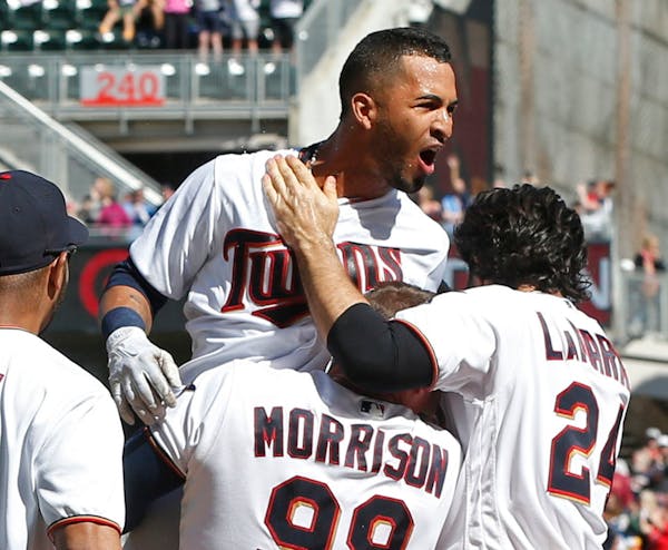 Minnesota Twins' Eddie Rosario, top, reacts after his walkoff two-run home run off Cleveland Indians' pitcher Cody Allen in the ninth inning of a base