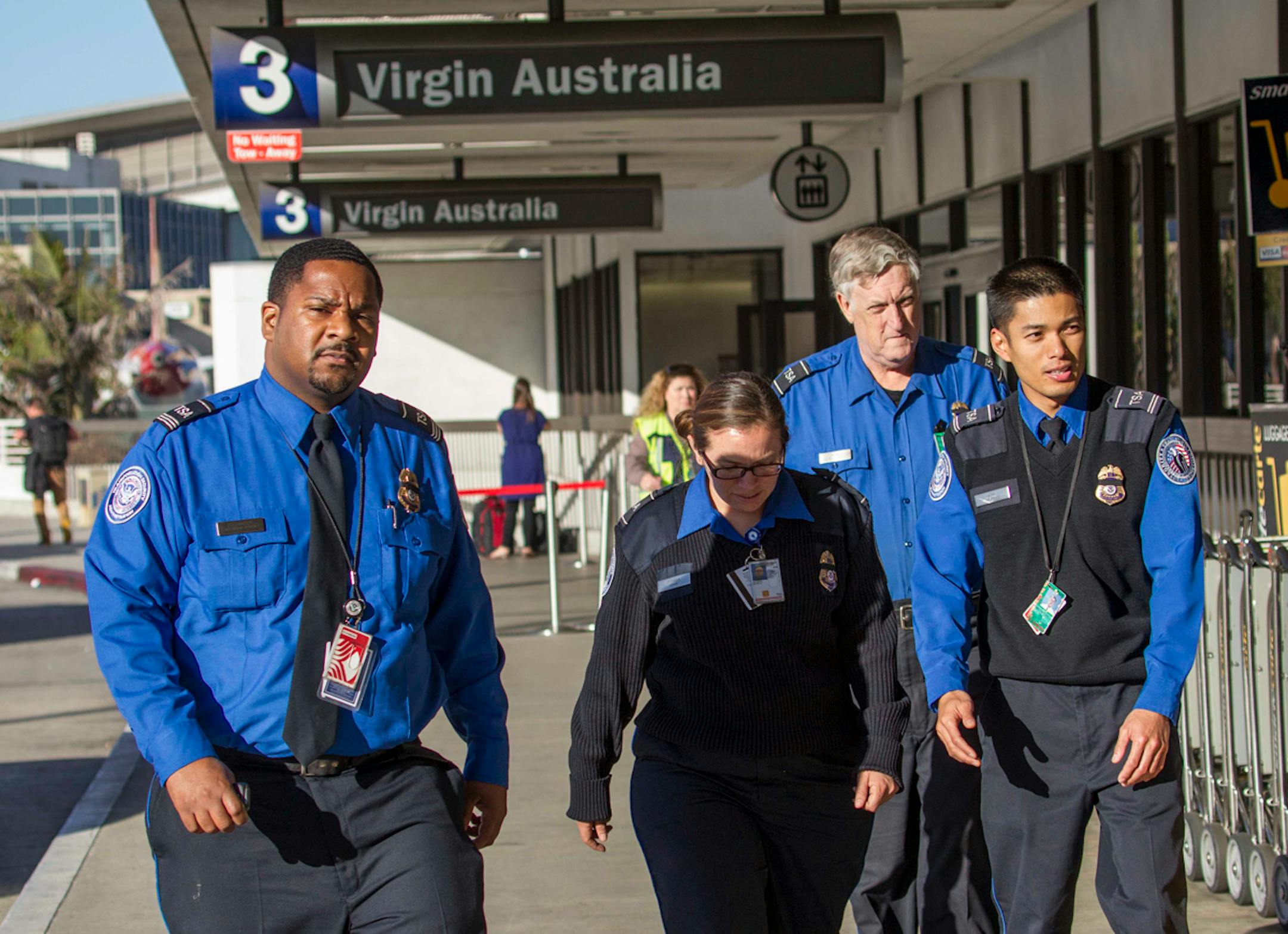Transportation Security Administration employees wear black ribbons over their badges on Saturday, Nov. 2, 2013, at Los Angeles International Airport. A gunman armed with a semi-automatic rifle opened fire at the airport on Friday, killing a Transportation Security Administration employee and wounding two other people in an attack that frightened passengers and disrupted flights nationwide. (AP Photo/Ringo H.W. Chiu)