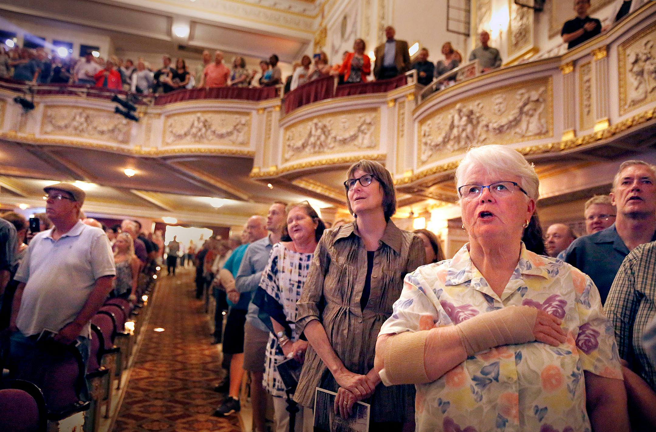 Kathy Beatty of Inver Grove Heights sings "The Star Spangled Banner" as Garrison Keillor leads the audience in song during the warm up to the live broadcast at the State Theatre.