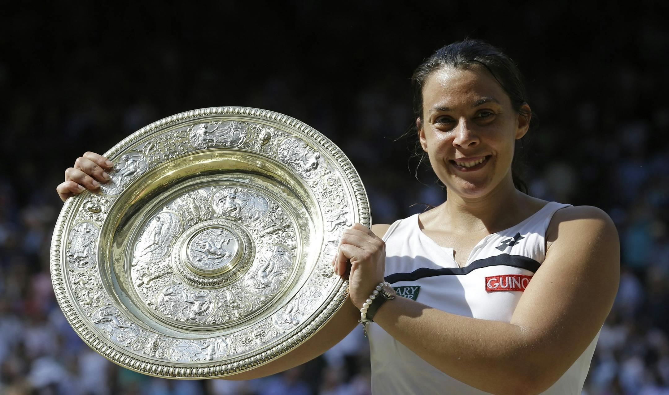Marion Bartoli of France smiles as she holds the trophy after winning the Women's singles final match against Sabine Lisicki of Germany at the All England Lawn Tennis Championships in Wimbledon, London, Saturday, July 6, 2013. (AP Photo/Anja Niedringhaus)