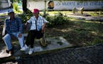 Men sit in a park where a mural of Cuba's late leader Fidel Castro reads in Spanish: "Death is not true" in Havana, Cuba, Friday, Nov. 24, 2017. The f