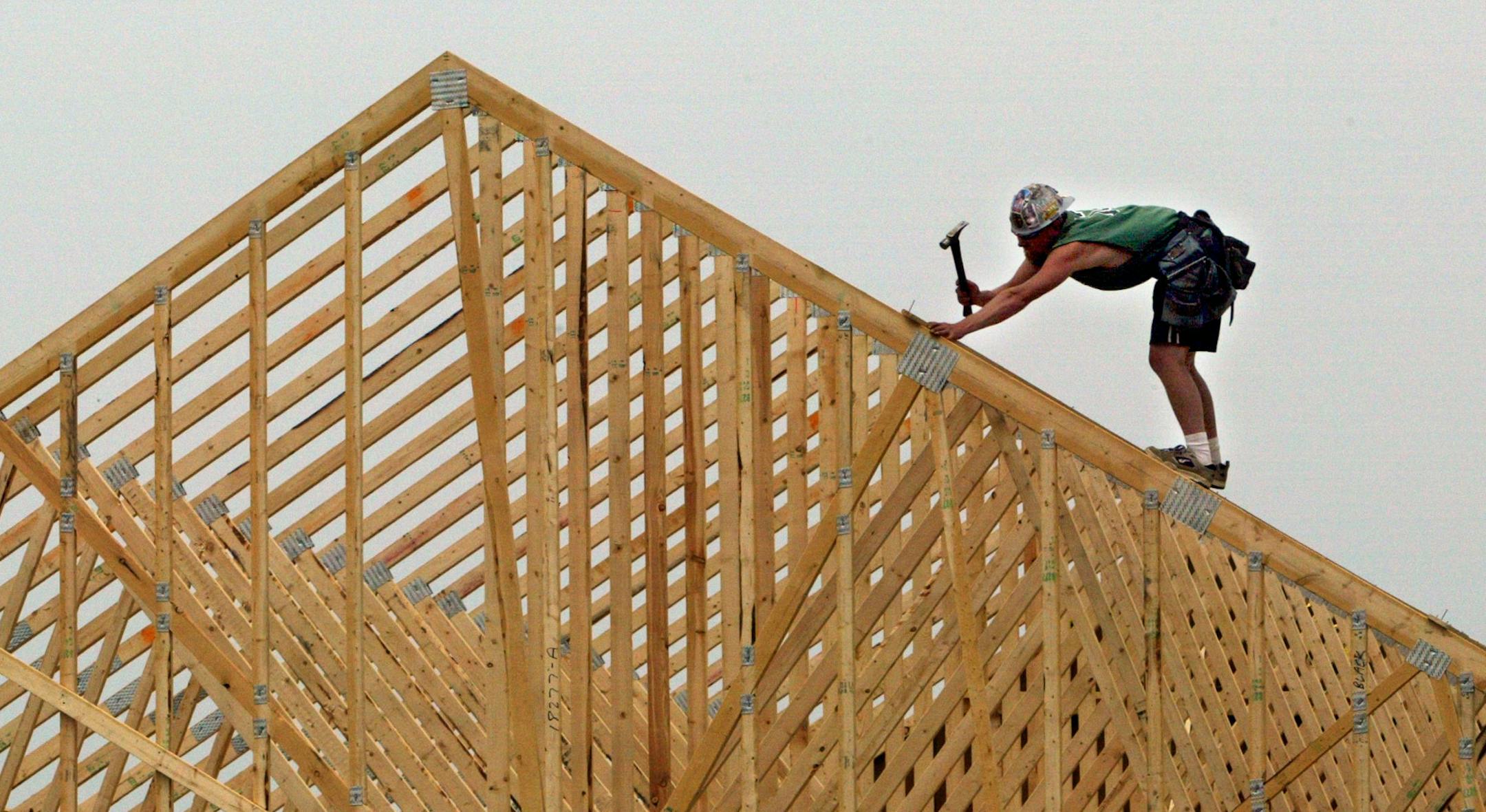Zach Hunter frames a roof on a new home under construction in Lakeville. (he works for GENCO builders).
GENERAL INFORMATION: Lakeville, MN 6/02/2003 The Dakota County city is one of several that found itself a last-minute target of budget negotiators at the State Capitol. Lakeville and other fast-growing, mostly Twin Cities suburban cities will not be able to use exemptions for growth in determining how much it can levy its taxpayers. That means that levying for things such as roads and sewers w