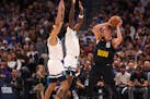 Kyle Anderson, left, and Naz Reid of the Wolves defended as Nuggets center Nikola Jokic looks to pass on Monday night in Denver.