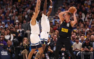 Kyle Anderson, left, and Naz Reid of the Wolves defended as Nuggets center Nikola Jokic looked to pass Monday night in Denver.