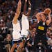 Minnesota Timberwolves forward Kyle Anderson, left, and center Naz Reid against Nuggets star Nikola Jokic (15) during the first quarter on Monday.