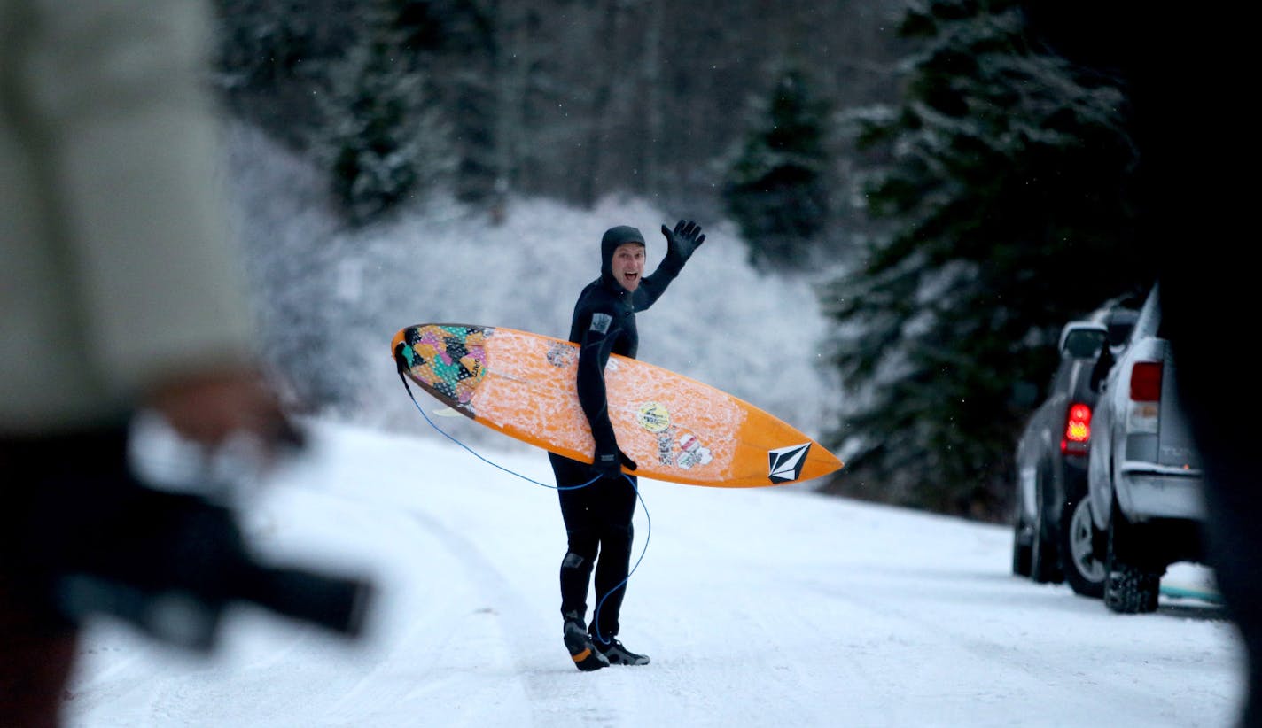 Pro surfer Alex Gray from California, front, waves to locals and friends and colleagues from Surfer Magazine before heading out to the waves of Lake Superior Thursday, March 17, 2016, at Stony Point, near Two Harbors, MN. Gray joined a group from Surfer Magazine who came to the North Shore to check out the unsalted waves. A passing front dropped some snow but also brought a stiff north wind, bringing waves nearing 10 feet and a small army of surfers.](DAVID JOLES/STARTRIBUNE)djoles@startribune.c