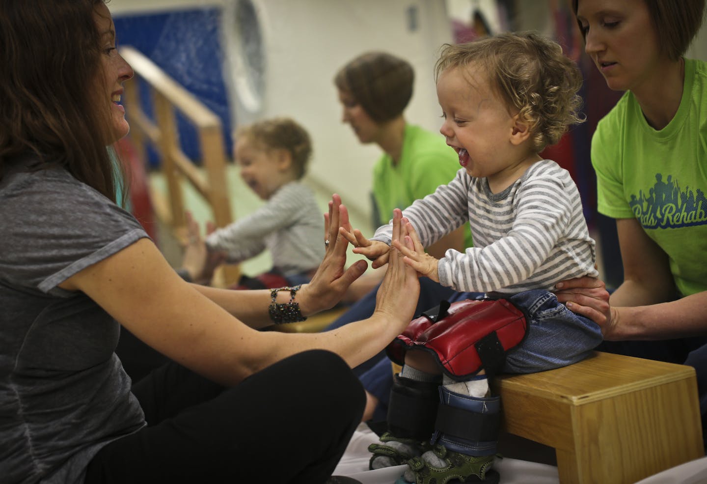 Two-year-old Wendell Sherman-Strand worked on playing pat-a-cake with his mother, Katie Sherman-Strand, during physical therapy with pediatric therapist Katie Larson at University of Minnesota Medical Center.