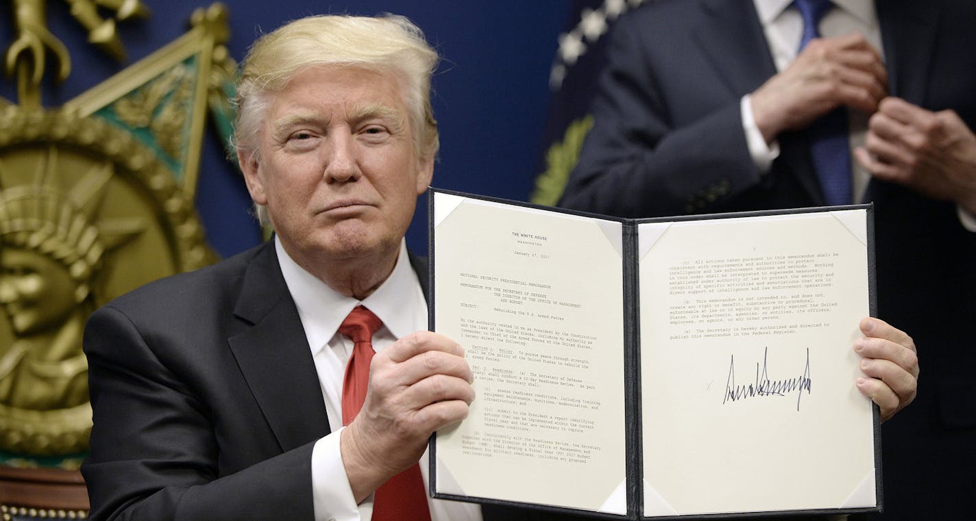 US President Donald Trump signs Executive Orders in the Hall of Heroes at the Department of Defense Friday, Jan. 27, 2017 in Arlington, Va. (Olivier Douliery/Abaca Press/TNS) ORG XMIT: 1196704 ORG XMIT: MIN1701271639110506