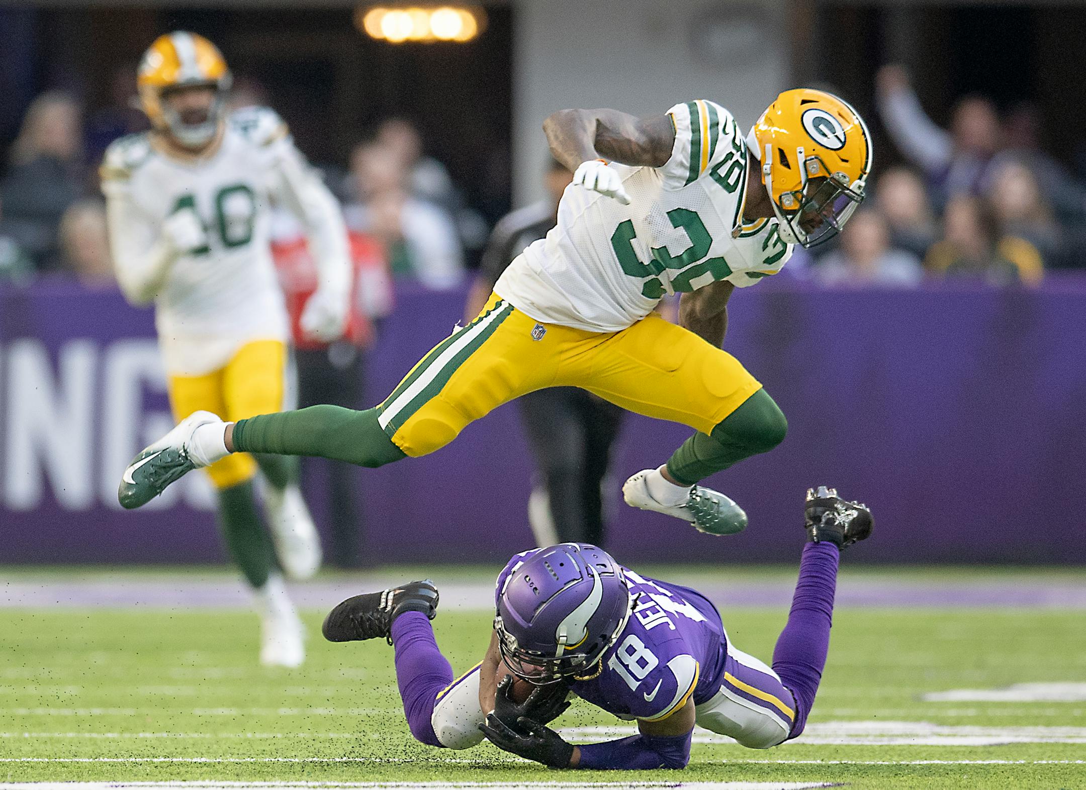 Vikings wide receiver Justin Jefferson (18) made a grab for a first down as Packers defensive back Chandon Sullivan (39) hurdles him during the third quarter.