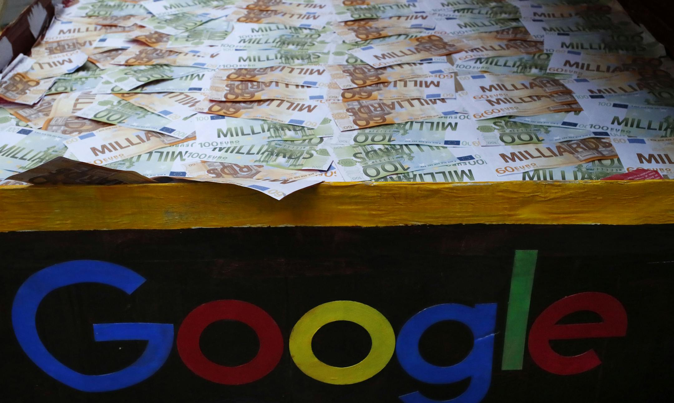FILE - In this Jan.31, 2019 file photo, a trunk full of fake bank notes is displayed as activists from anti-globalization organisation Attac stage a protest at Google's Paris headquarters to criticize the company's tax evasion policies, in Paris. The French government is unveiling plans to slap a 3 percent tax on the French revenues of internet giants like Google, Amazon and Facebook. (AP Photo/Francois Mori, File) ORG XMIT: PAR102