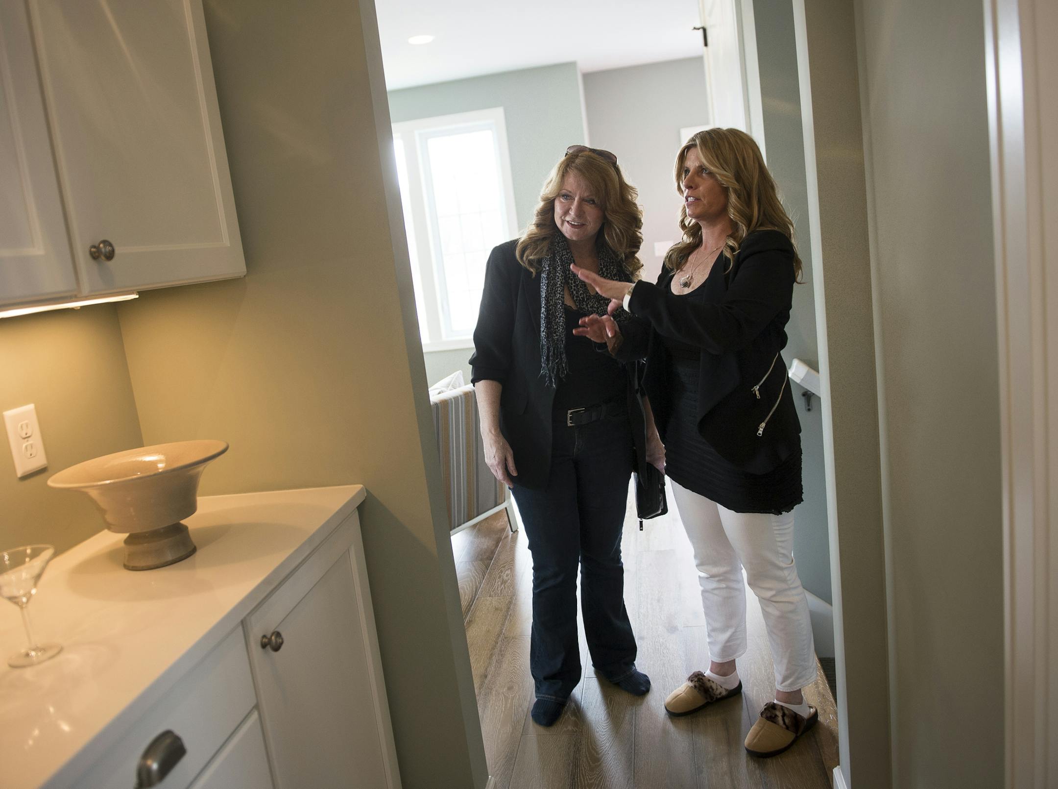 Potential buyer Judy Black, left, was assisted by real estate agent Nicole Reed as she toured a model home in Minneapolis in 2016.