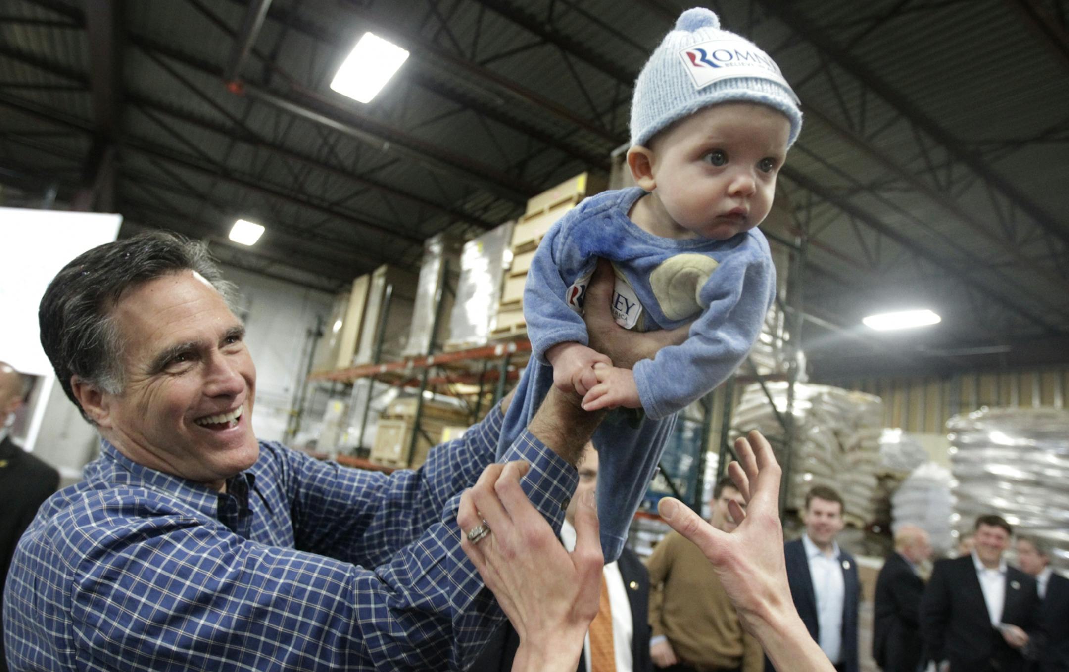Mitt Romney passed 6-month old Dexter Hall to his mother Laura Hall of Plymouth, at Freightmasters Trucking Wednesday in Eagan.