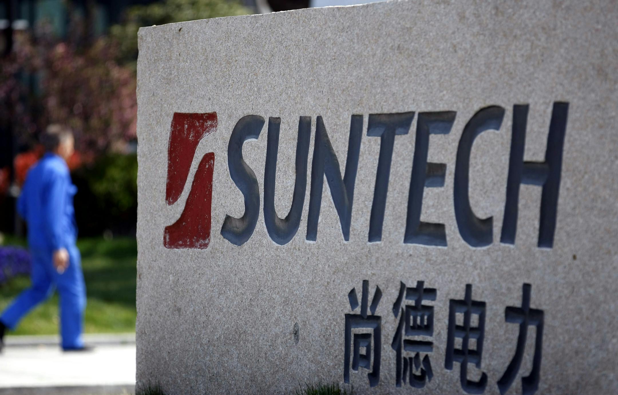 A man walks near the headquarters of Suntech Power Holdings Ltd. in Wuxi, in eastern China's Jiangsu province Thursday March 21, 2013. Suntech, one of the world's biggest solar panel manufacturers, was forced into bankruptcy court Wednesday, becoming the latest casualty of a painful slump in the global solar industry. (AP Photo) CHINA OUT ORG XMIT: MIN2013032515164941