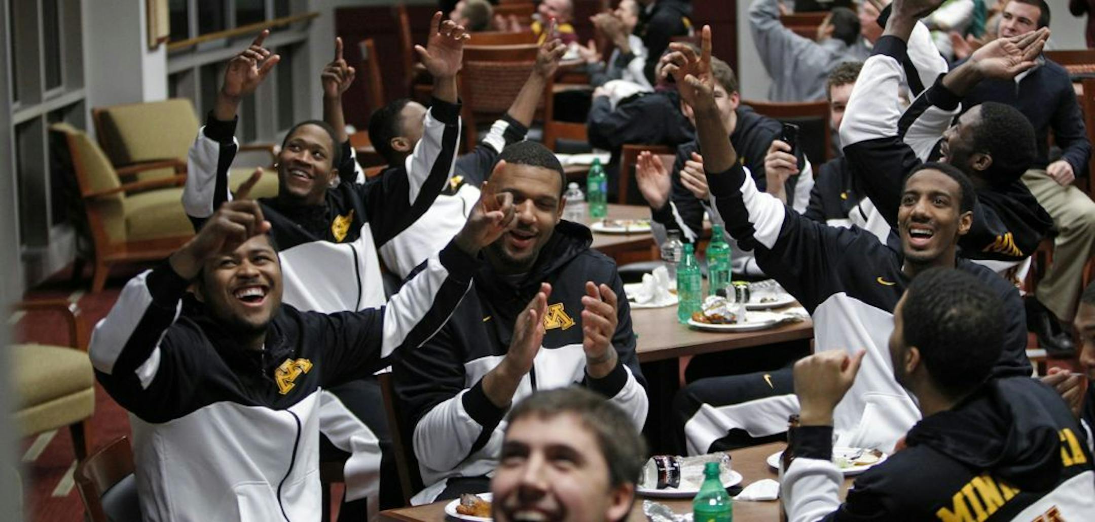 Gophers players react to the NCAA pairings announcement Sunday in the Pavilion Club room at the U of M. IDs... Front table is Maverick Ahanmisi; Maurice Walker; Austin Hollins (L to R). back table is Rodney Williams on left.; PHOTO CREDIT: Eric Miller - University of Minnesota