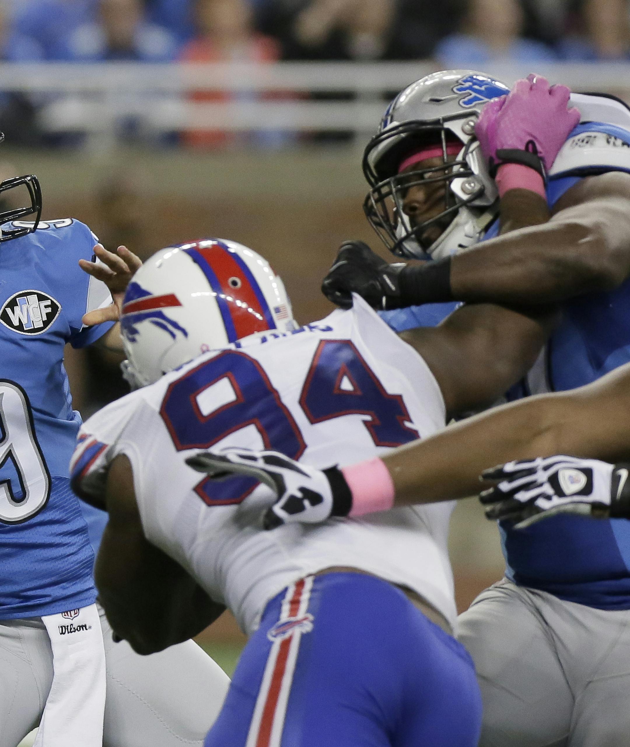 Detroit Lions tight end Brandon Pettigrew, right, blocks against Buffalo Bills defensive end Mario Williams (94) as Detroit Lions quarterback Matthew Stafford (9) passes the ball during an NFL football game Sunday, Oct. 5, 2014, in Detroit. (AP Photo/Duane Burleson)