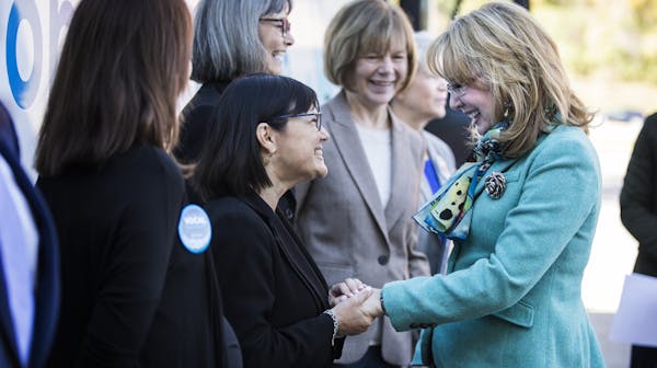 Former U.S. Rep. Gabrielle Giffords, right, greets Terri Bonoff, candidate for Minnesota's 3rd congressional district, during a kickoff event for gun 