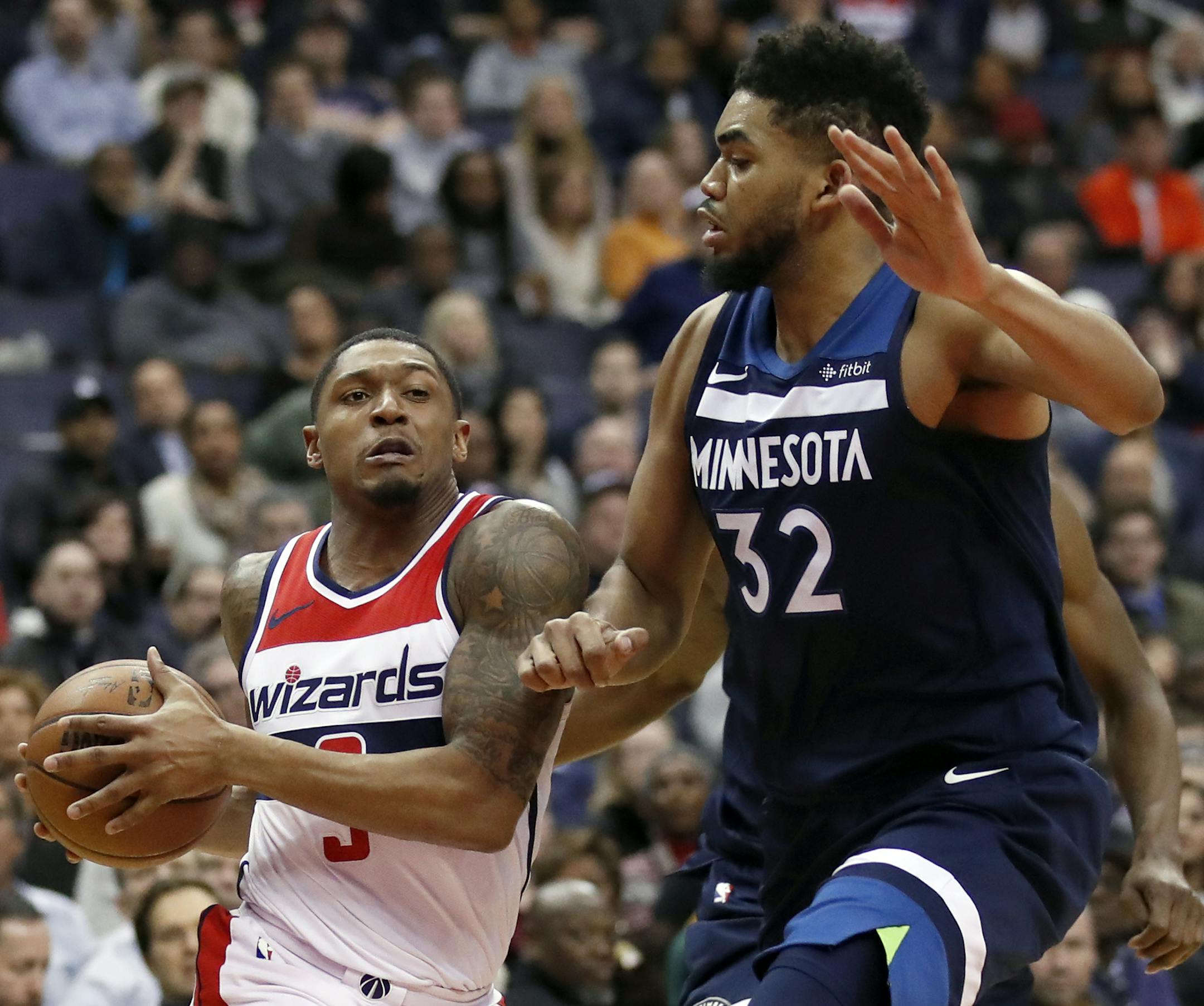 Washington Wizards guard Bradley Beal, left, drives against Minnesota Timberwolves center Karl-Anthony Towns during the second half of an NBA basketball game, Tuesday, March 13, 2018, in Washington. The Timberwolves won 116-111. (AP Photo/Alex Brandon)