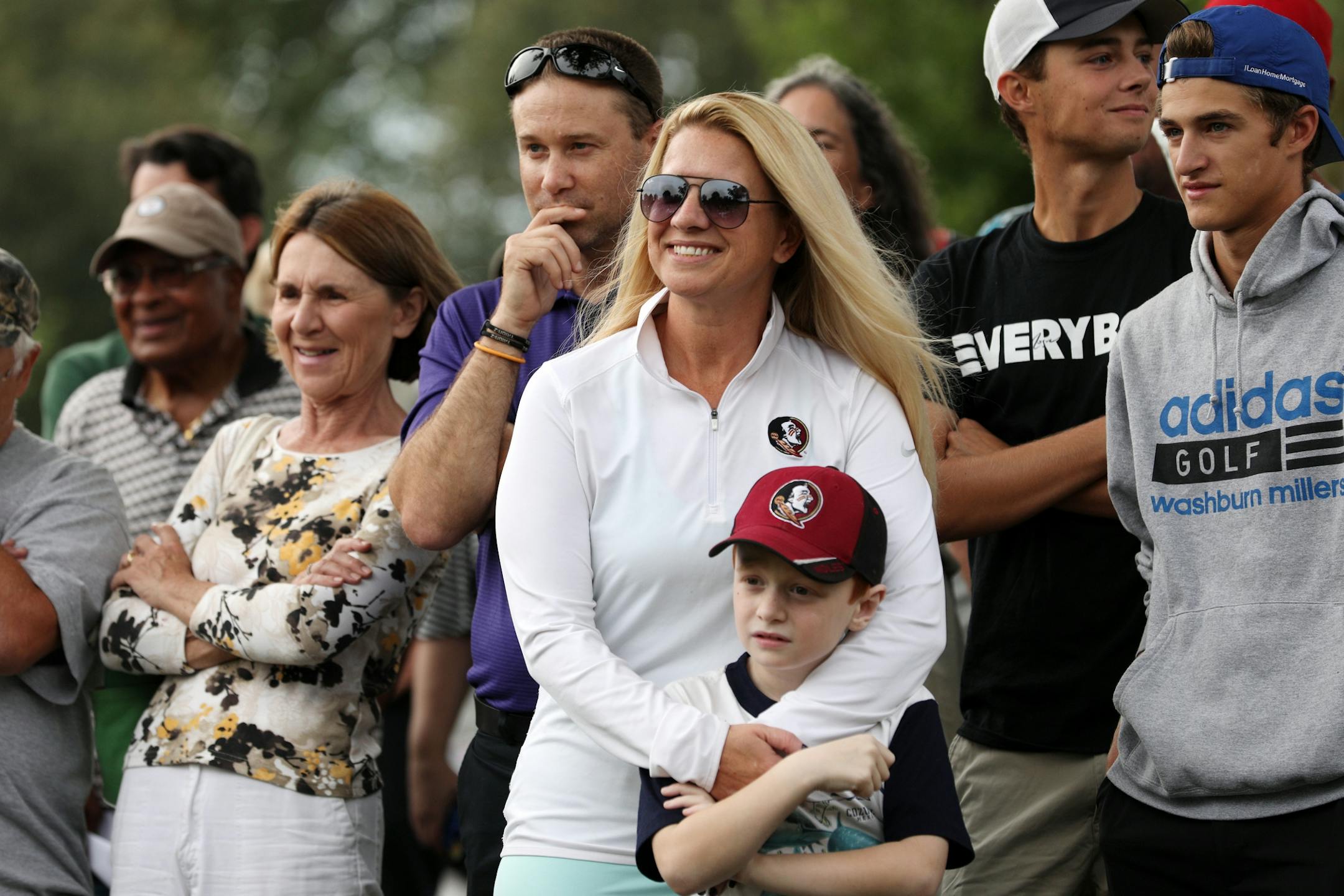 Alison Reddig stood with her arm around her son Quinn, 7, among other golfers and supporters of the Hiawatha Golf Course as they rallied against the Park Board's recent decision to reduce pumping and close the course at the end of 2019 season Tuesday. Her other son Parker, 18, at right in black, got an athletic scholarship to Florida State University after learning to play on the course since he was 2-years-old.