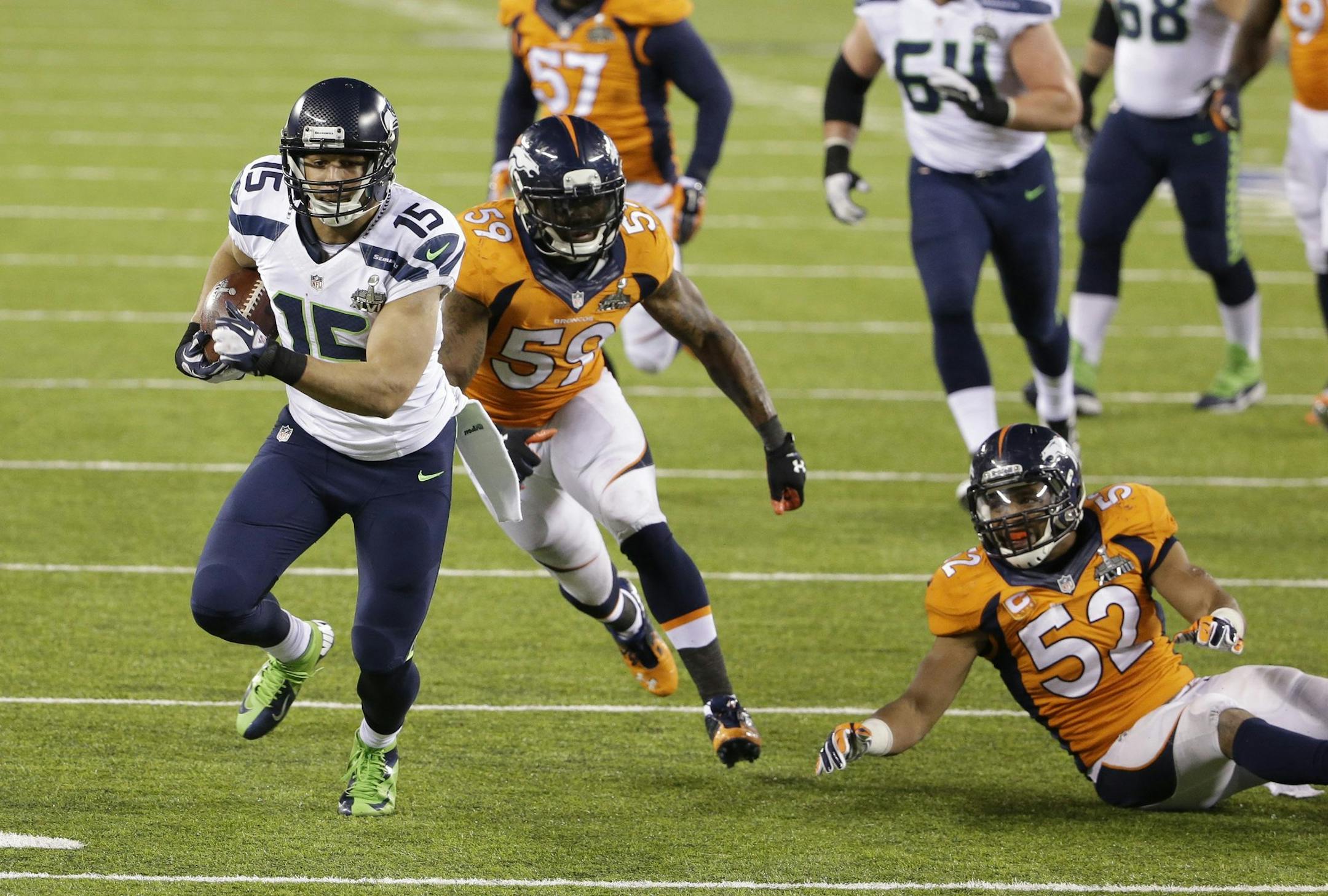 Jermaine Kearse (15) of the Seattle Seahawks eludes Danny Trevathan (59) and Wesley Woodyard (52) of the Denver Broncos on his way to a touchdown during the second half of Super Bowl XLVIII at MetLife Stadium in East Rutherford, N.J., on Sunday, Feb. 2, 2014. (J. Patric Schneider/MCT)
