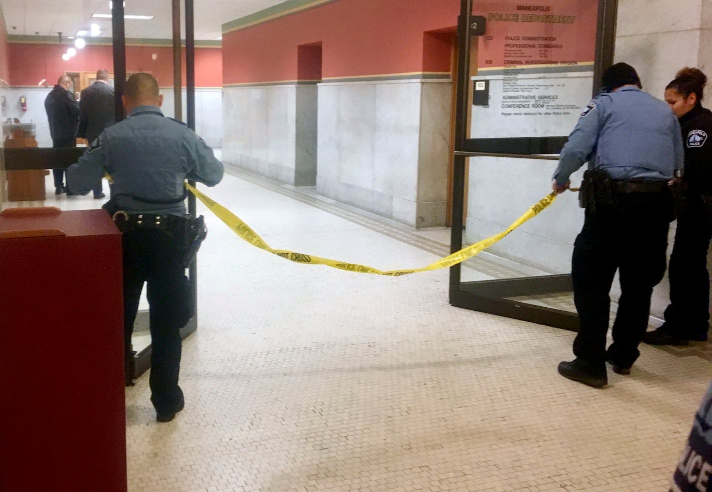 Police set up crime scene tape outside a Minneapolis police room at Minneapolis City Hall on Monday.