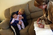Krystal Woods held her five-month-old daughter Me'yah Becker as nurse Barb Lentz checked on her prescriptions on a recent home visit.