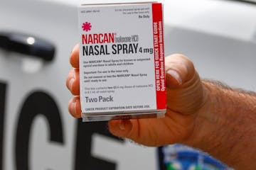 FILE - In this Thursday, Sept. 12, 2019 file photo, a police officer holds a box of Narcan, a drug used to treat opioid overdoses, that the department