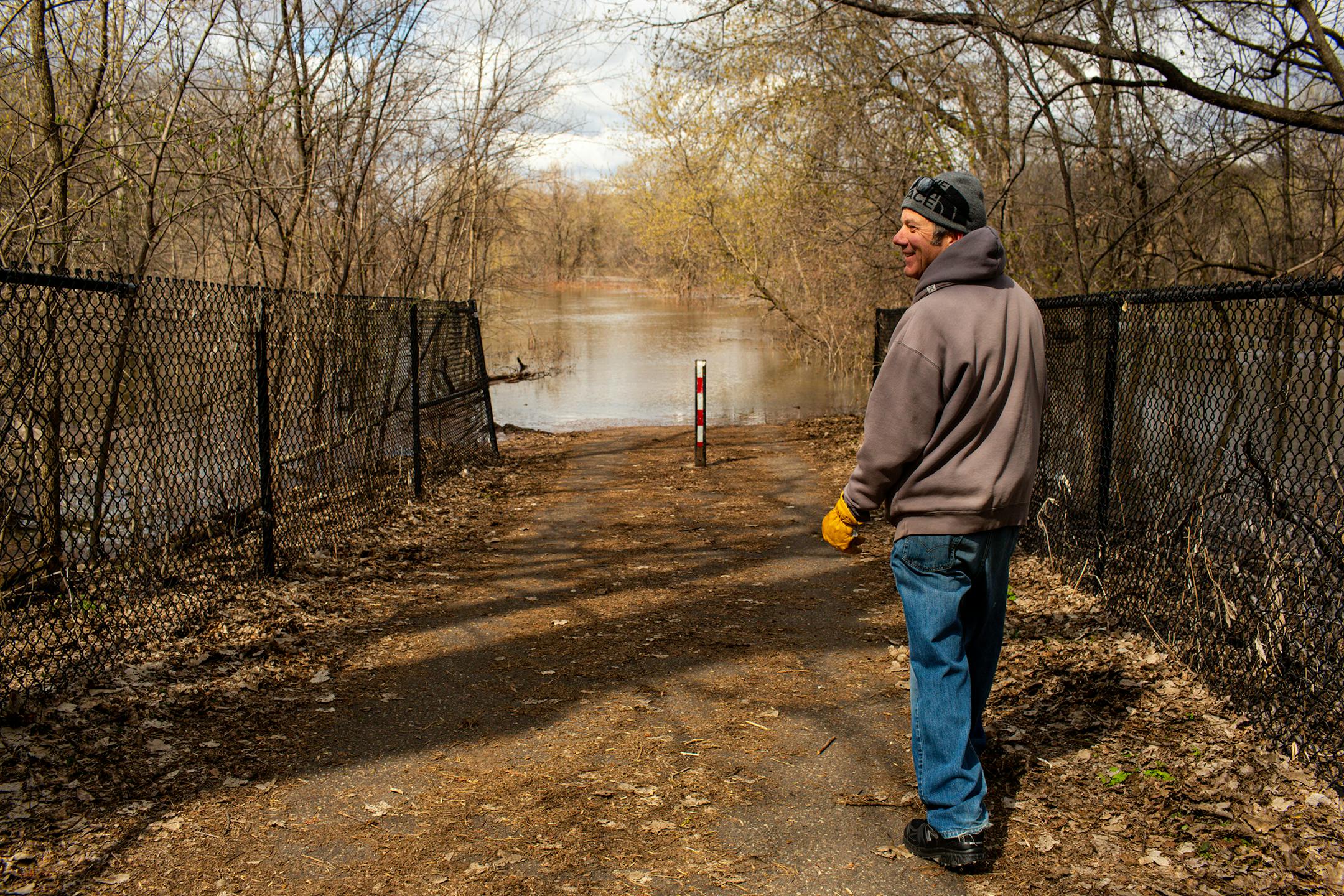 Jeff Ringsred of Bloomington walks down to a submerged bike path along the Minnesota River on Sunday, April 23, 2023, during a period of high spring flooding in Bloomington.