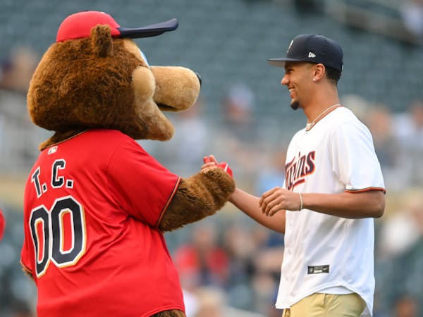 Gonzaga star basketball player and former Minnehaha Academy star Jalen Suggs high fived T.C. Bear after he threw the ceremonial first pitch Thursday n