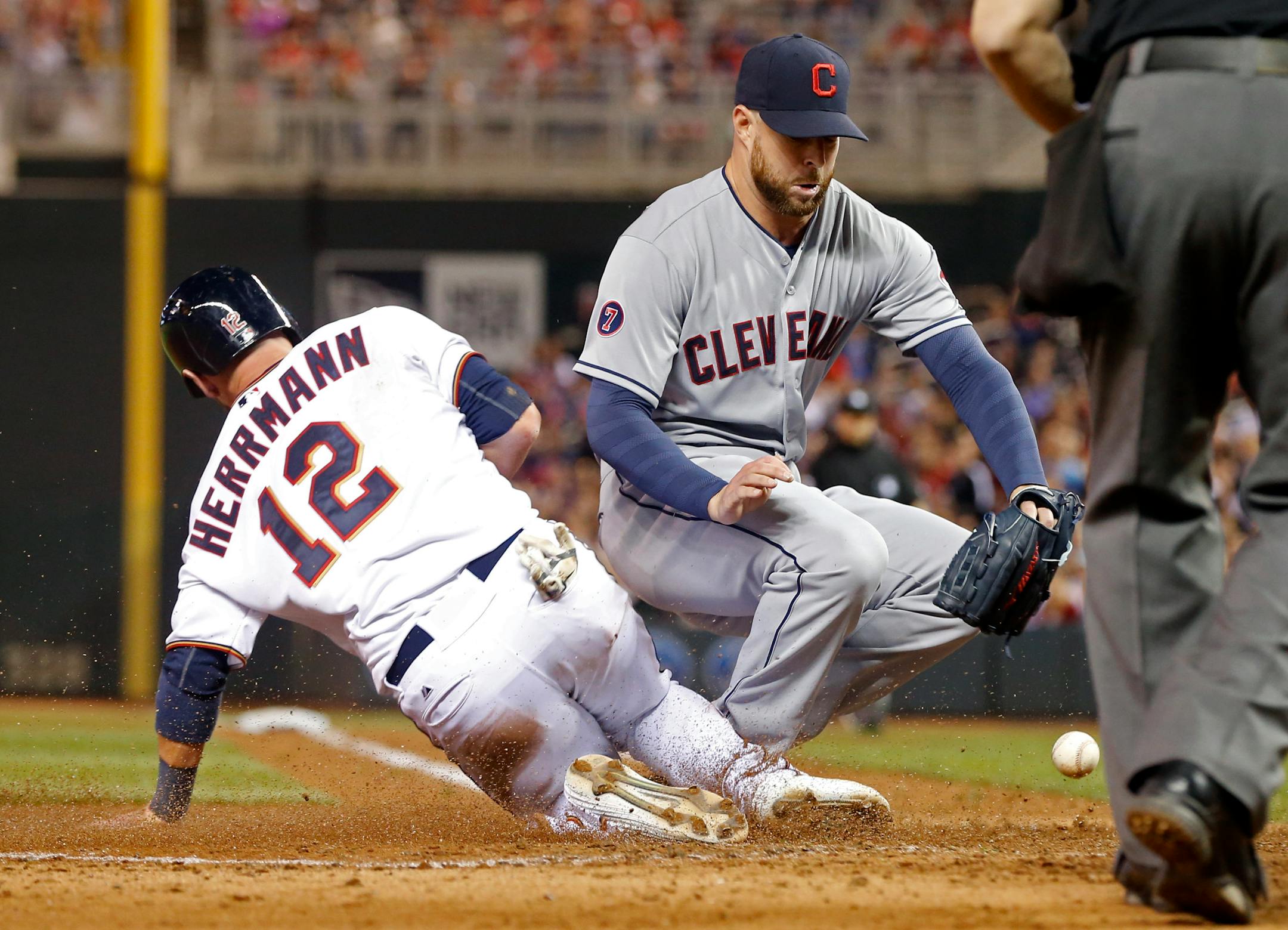 Cleveland Indians pitcher Corey Kluber, right, reaches for the ball as he covered home, allowing Minnesota Twins� Chris Herrmann, right, to tiei the score on his wild pitch in the sixth inning of a baseball game, Friday, April 17, 2015, in Minneapolis. (AP Photo/Jim Mone)