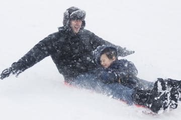 On a hill at Lyndale Farmstead in Minneapolis, Julian Fischer and his son, Zavoli, 5, took advantage of the Sunday's snow.