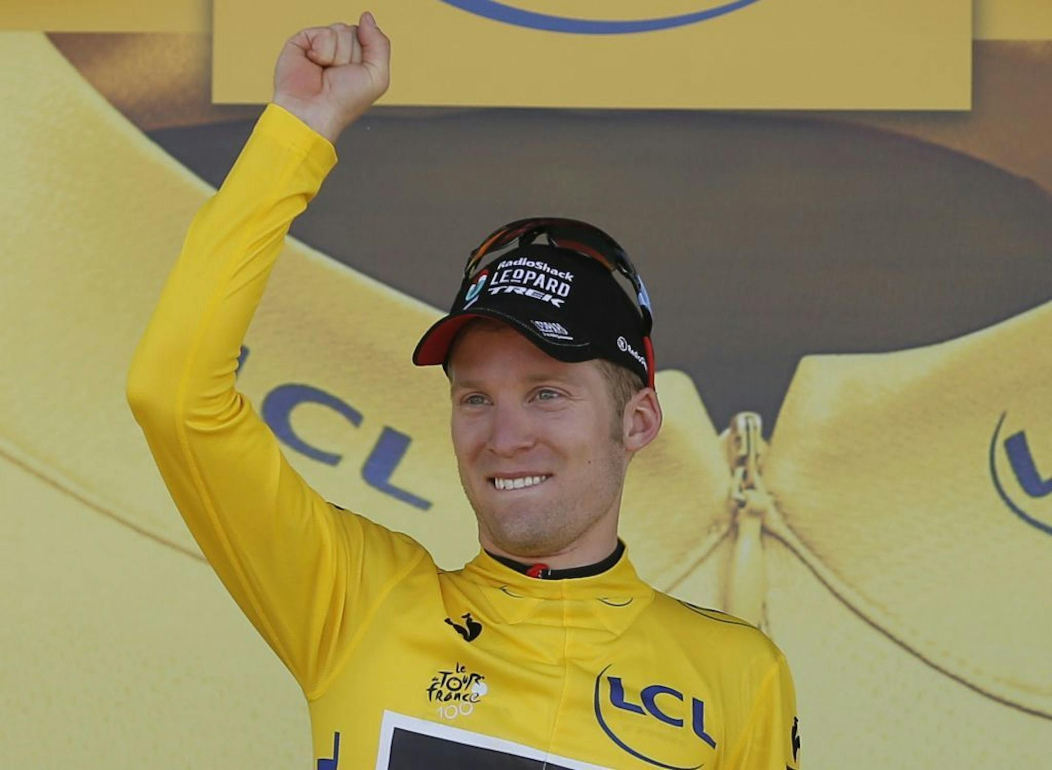 Jan Bakelants of Belgium, wearing the overall leader's yellow jersey, celebrates on the podium of the second stage of the Tour de France cycling race over 156 kilometers (97.5 miles) with start in Bastia and finish in Ajaccio, Corsica island, France, Sunday June 30, 2013.