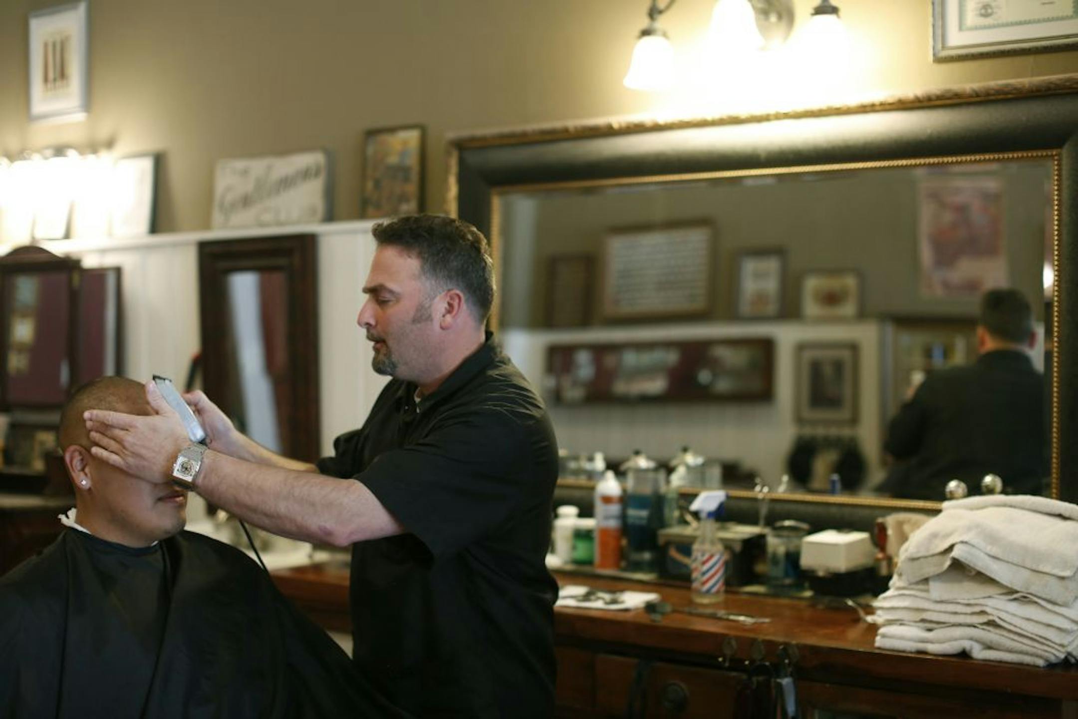At Shattuck's St. Mary's in Faribault, barber Marvin Lloyd gives client Victor Moreno a haircut. Lloyd acknowledges the large influence the school wields over the town .
