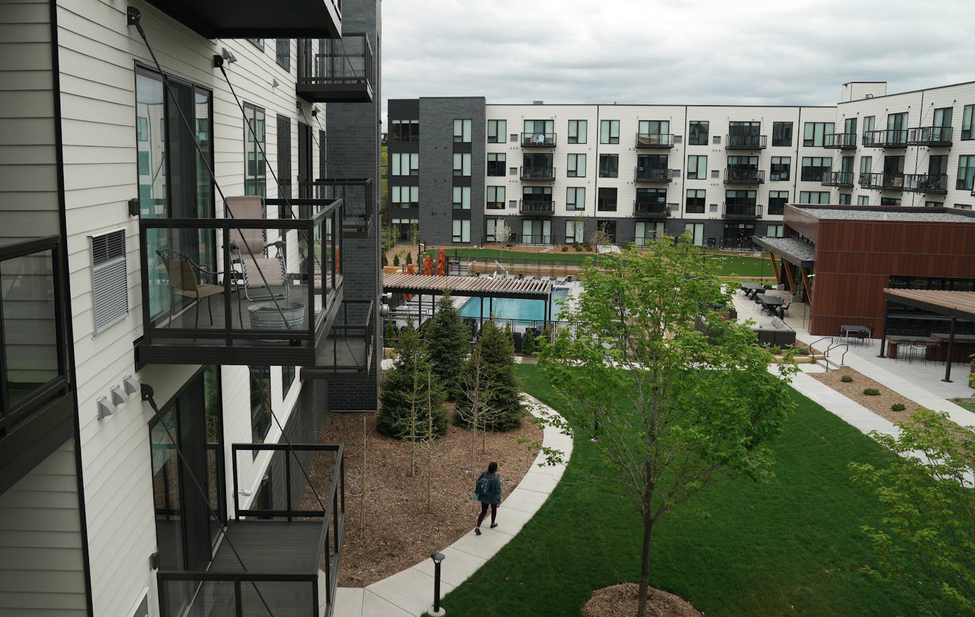 A resident walked between buildings at The Loden. ] ANTHONY SOUFFLE &#x2022; anthony.souffle@startribune.com Life at The Loden, a new apartment complex with high end amenities that filled up in three months, Thursday, May 23, 2019 in Shoreview, Minn. The city used a PUD to get around existing suburban rules and build to meet market demand.