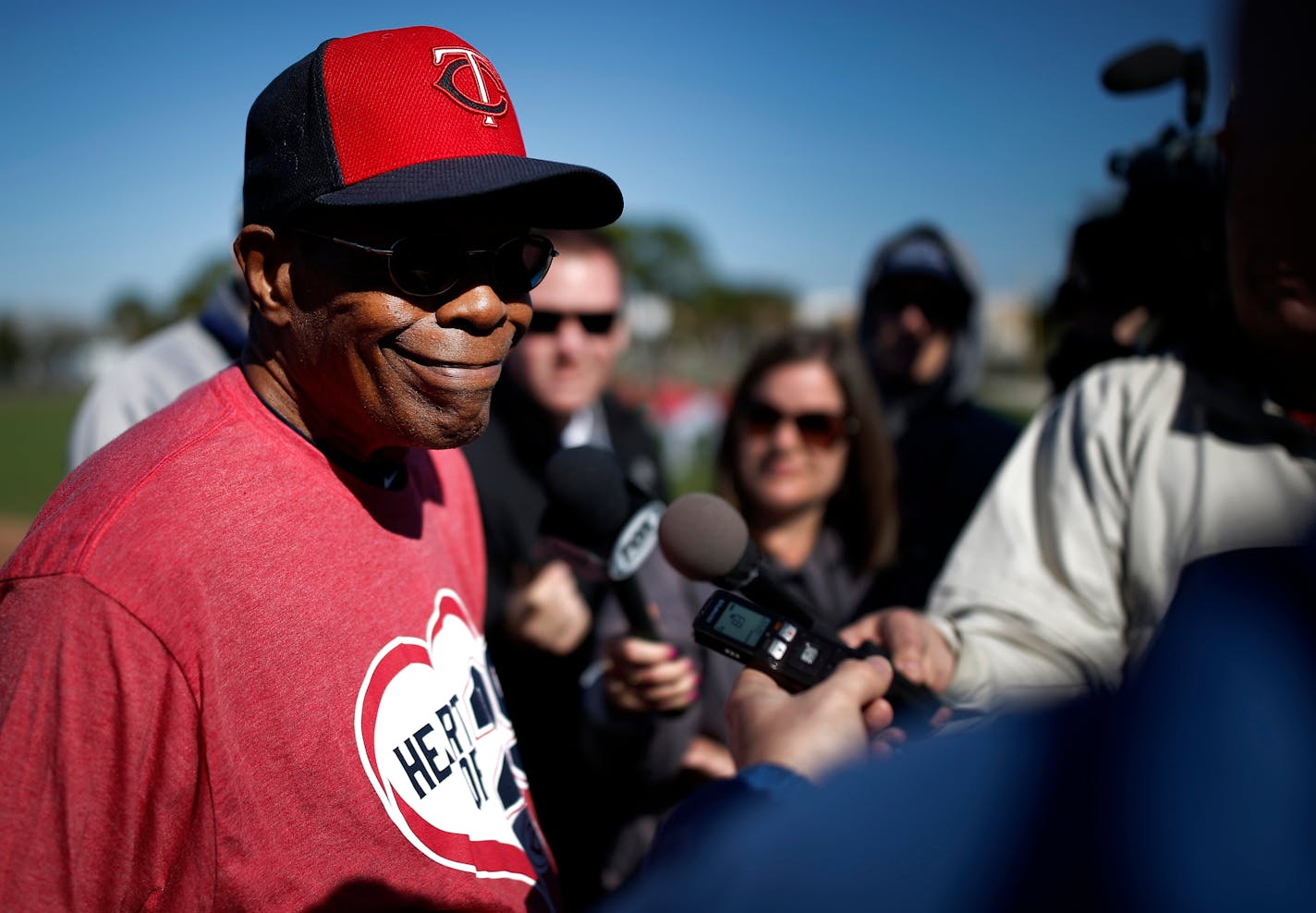 Hall of Famer Rod Carew, awaiting a heart transplant, flashed his familiar smile after arriving at Twins spring training Saturday.