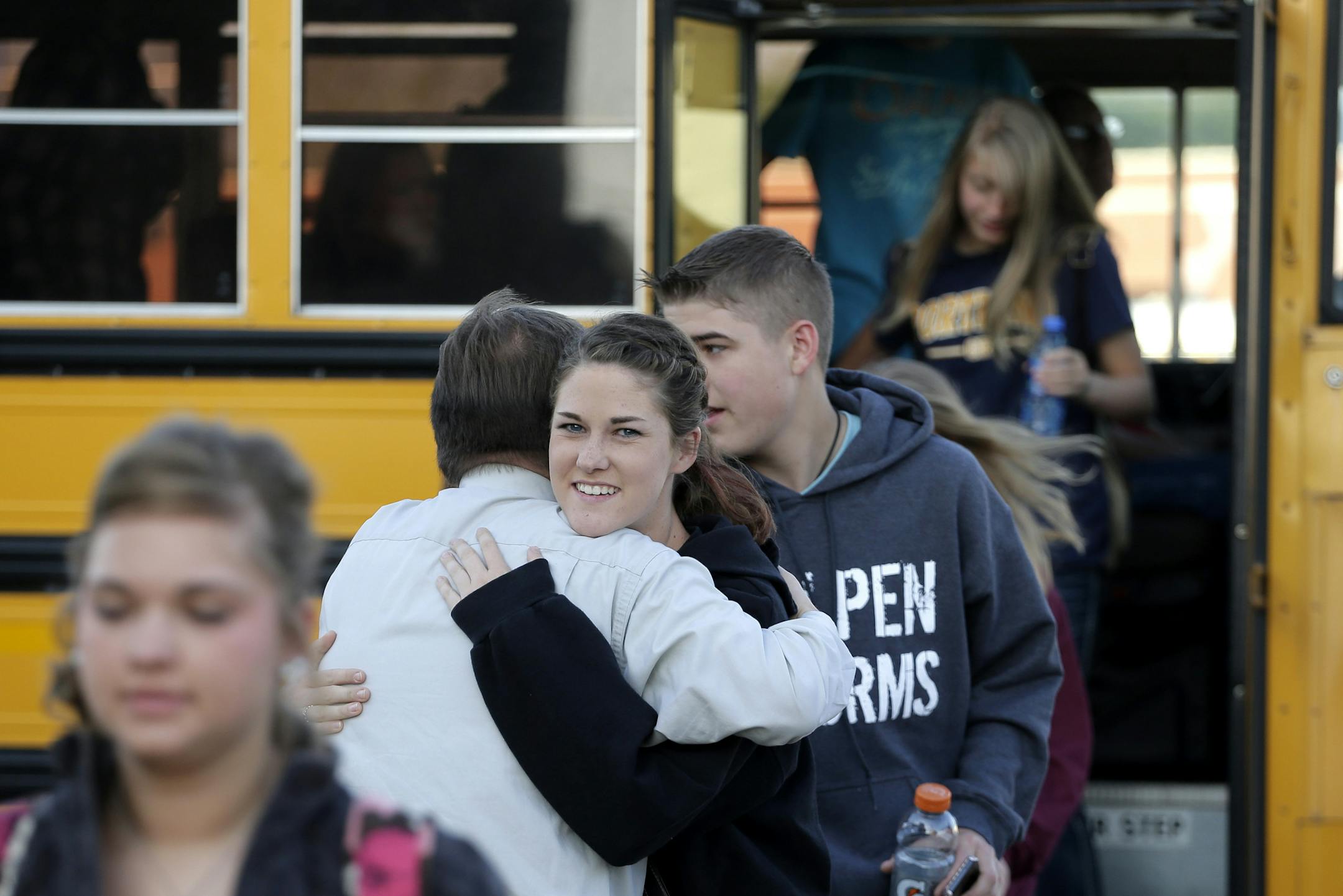 A high school student gets a hug from a teacher from West, Texas, as students arrive for classes at a temporary facility provided by the Connally Independent School District Monday, April 22, 2013, in Waco, Texas. West students returned back to class today after a massive explosion at the West Fertilizer Co. five days ago damaged three of West's four schools, killed 14 people and injured more than 160 others. (AP Photo/Charlie Riedel)