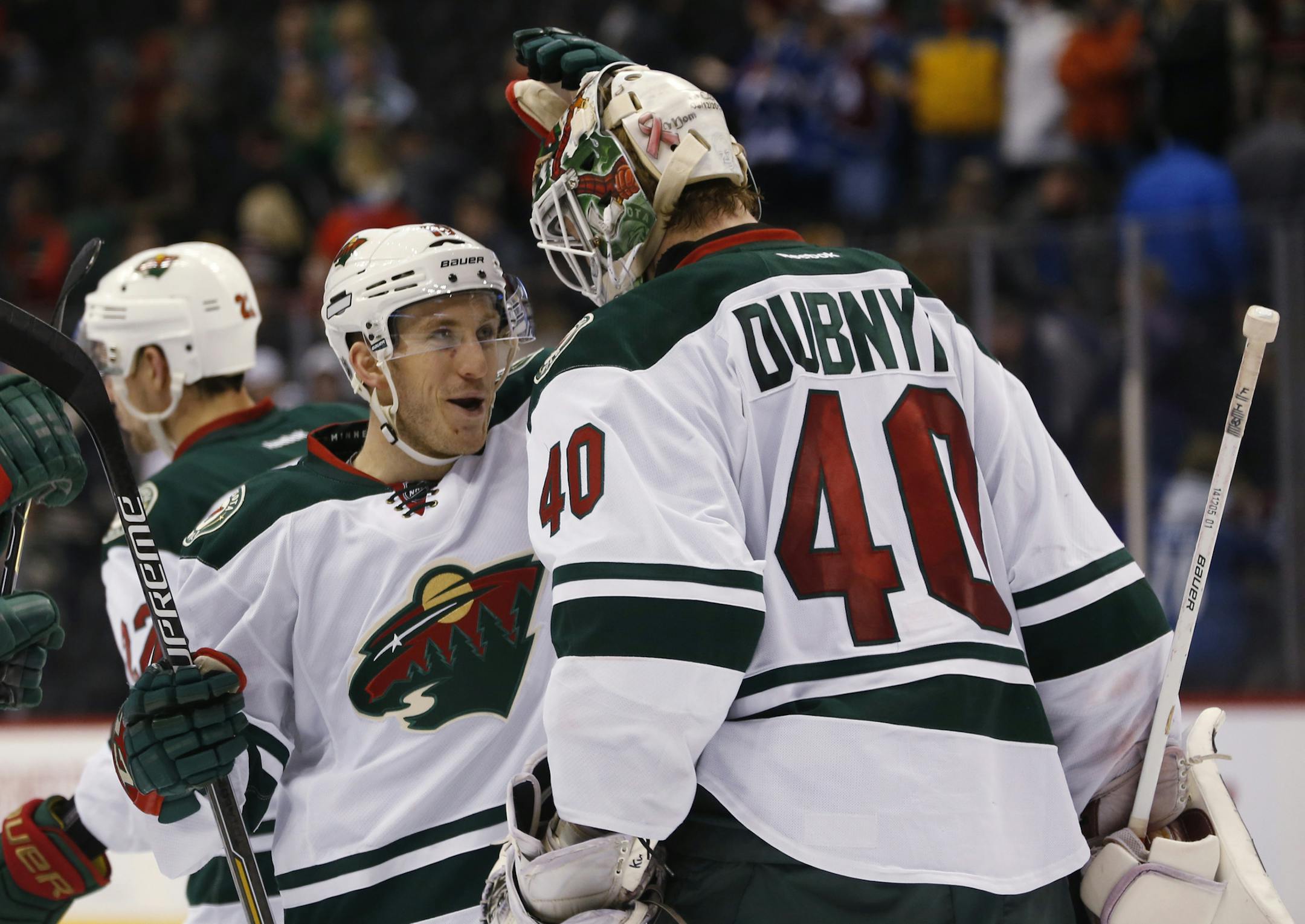 Minnesota Wild center Jordan Schroeder, left, congratulates goalie Devan Dubnyk as time runs out against the Colorado Avalanche in the third period of an NHL hockey game Saturday, Feb. 28, 2015, in Denver. The Wild won 3-1. (AP Photo/David Zalubowski)
