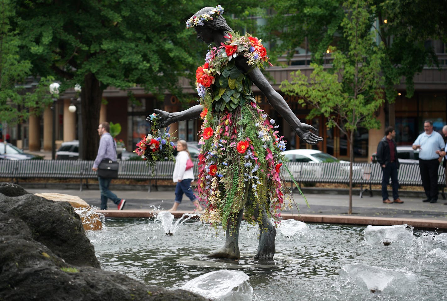 A remade version of St. Paul's historic Rice Park was unveiled at a ceremony Tuesday afternoon. The new park modifications include a more open design with entry corners with seat walls, raised garden beds by the St. Paul Garden Club and a central space for events and gatherings. Here, the girl in the fountain remains and was decked out in flowers Tuesday afternoon.]