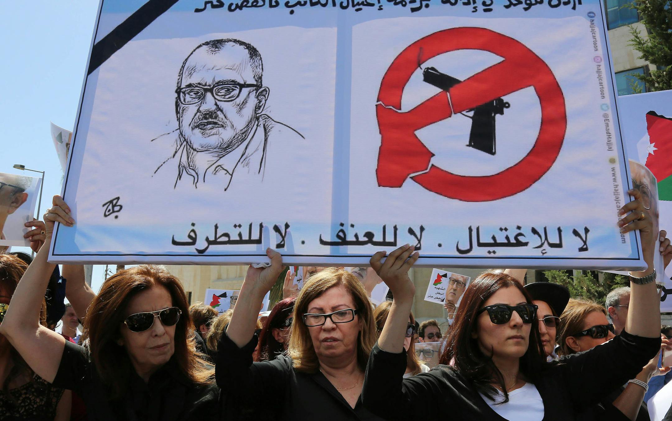 Relatives of Jordanian writer Nahed Hattar protest in front of Jordanian Prime Ministry in Amman, Jordan on Monday, Sept. 26, 2016, to demand the overthrow Jordanian Prime Minister Hani al-Mulki over Hattar's death. The prominent and outspoken Jordanian writer on Sunday was shot dead in front of the courthouse where he had been on trial for posting a cartoon deemed offensive to Islam on social media. Sign reads in Arabic: No to assassination, no to violence, no to extremism. (AP Photo/Raad Adayl