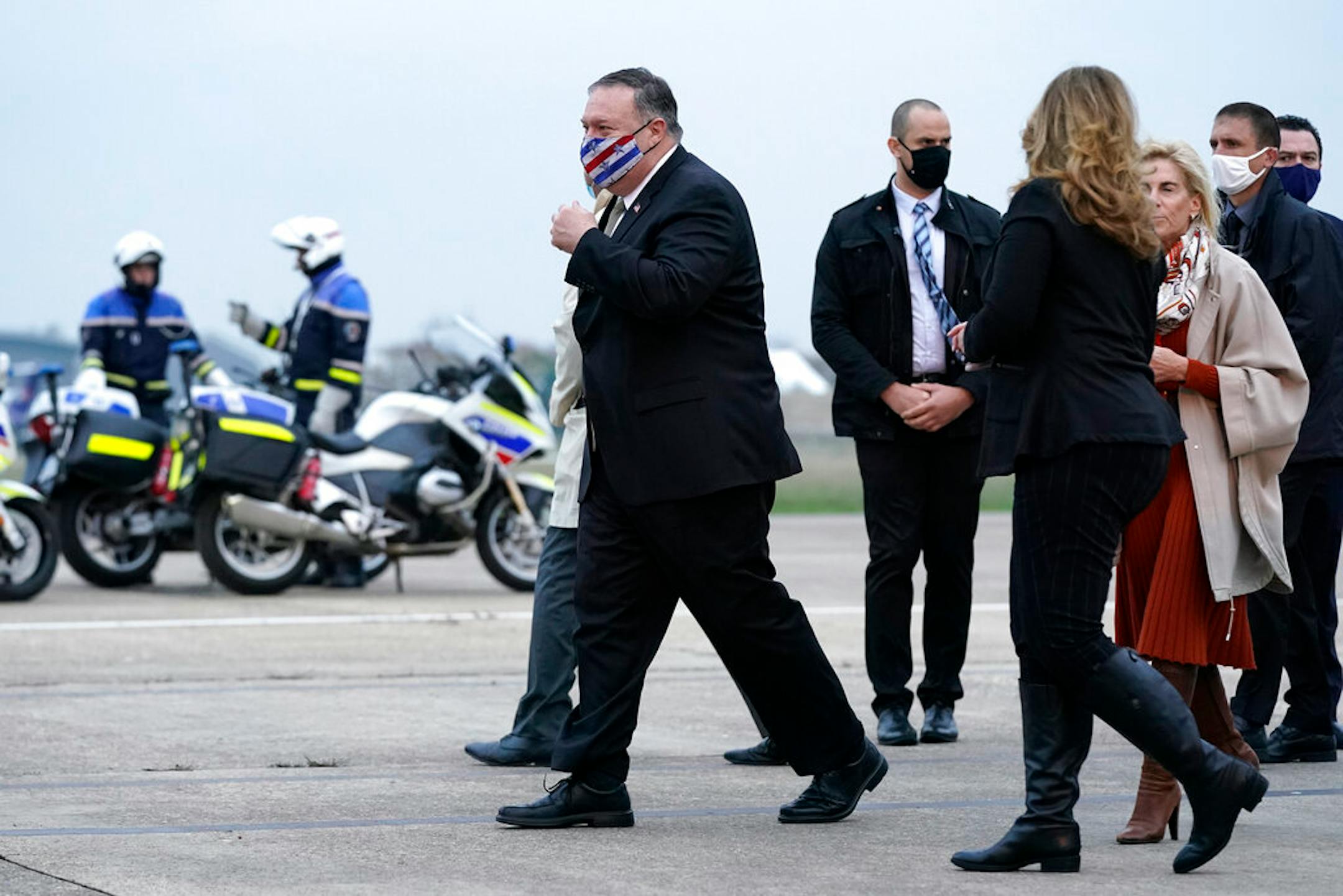 U.S. Secretary of State Mike Pompeo, left, walks to a motorcade vehicle after stepping off a plane at Paris Le Bourget Airport, Saturday, Nov. 14, 2020, in Le Bourget, France. Pompeo is beginning a 10-day trip to Europe and the Middle East.