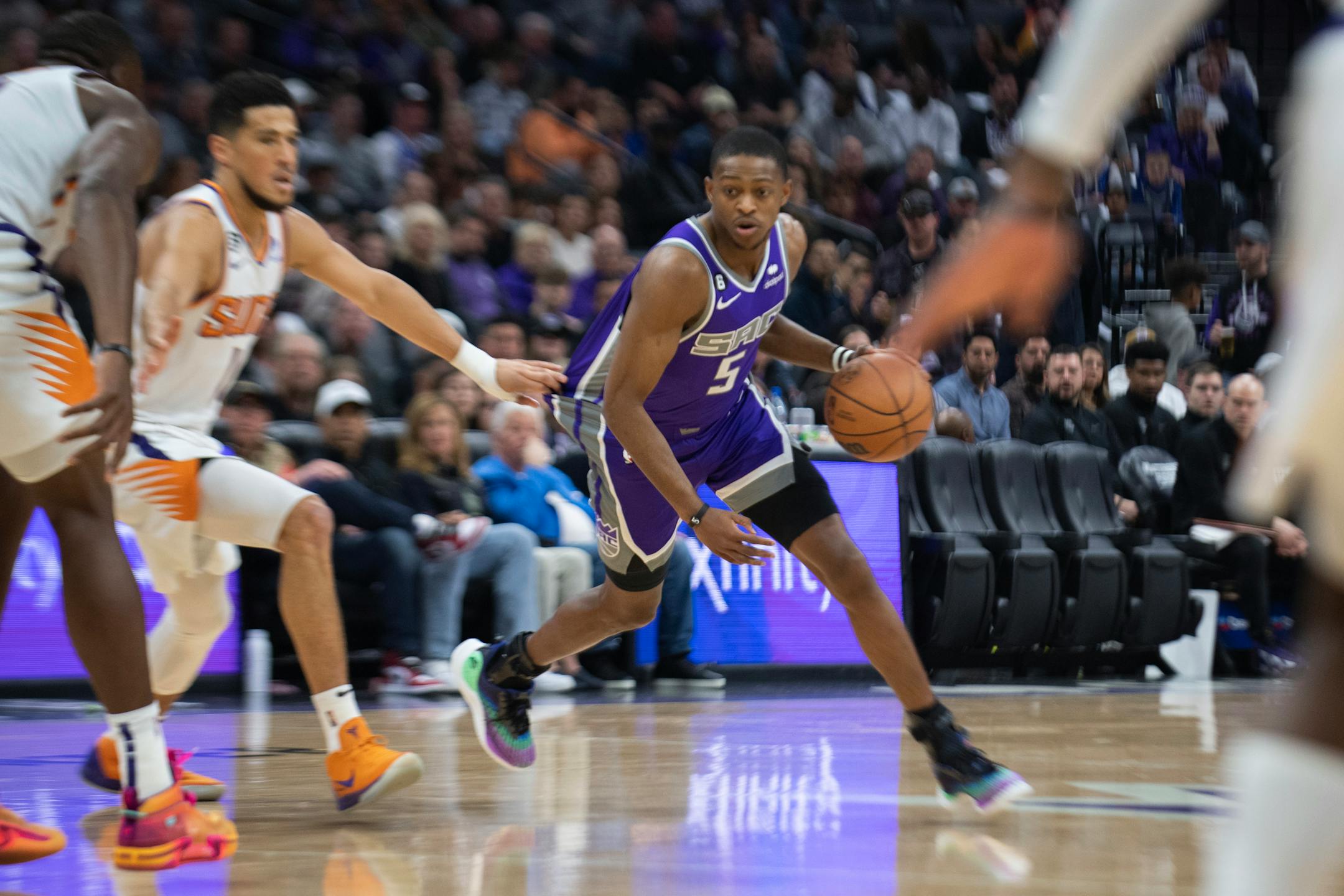 Sacramento Kings guard De'Aaron Fox (5) looks to drive as Phoenix Suns guard Devin Booker (1) defends in the first quarter in an NBA basketball game in Sacramento, Calif., Friday, March 24, 2023. (AP Photo/José Luis Villegas)
