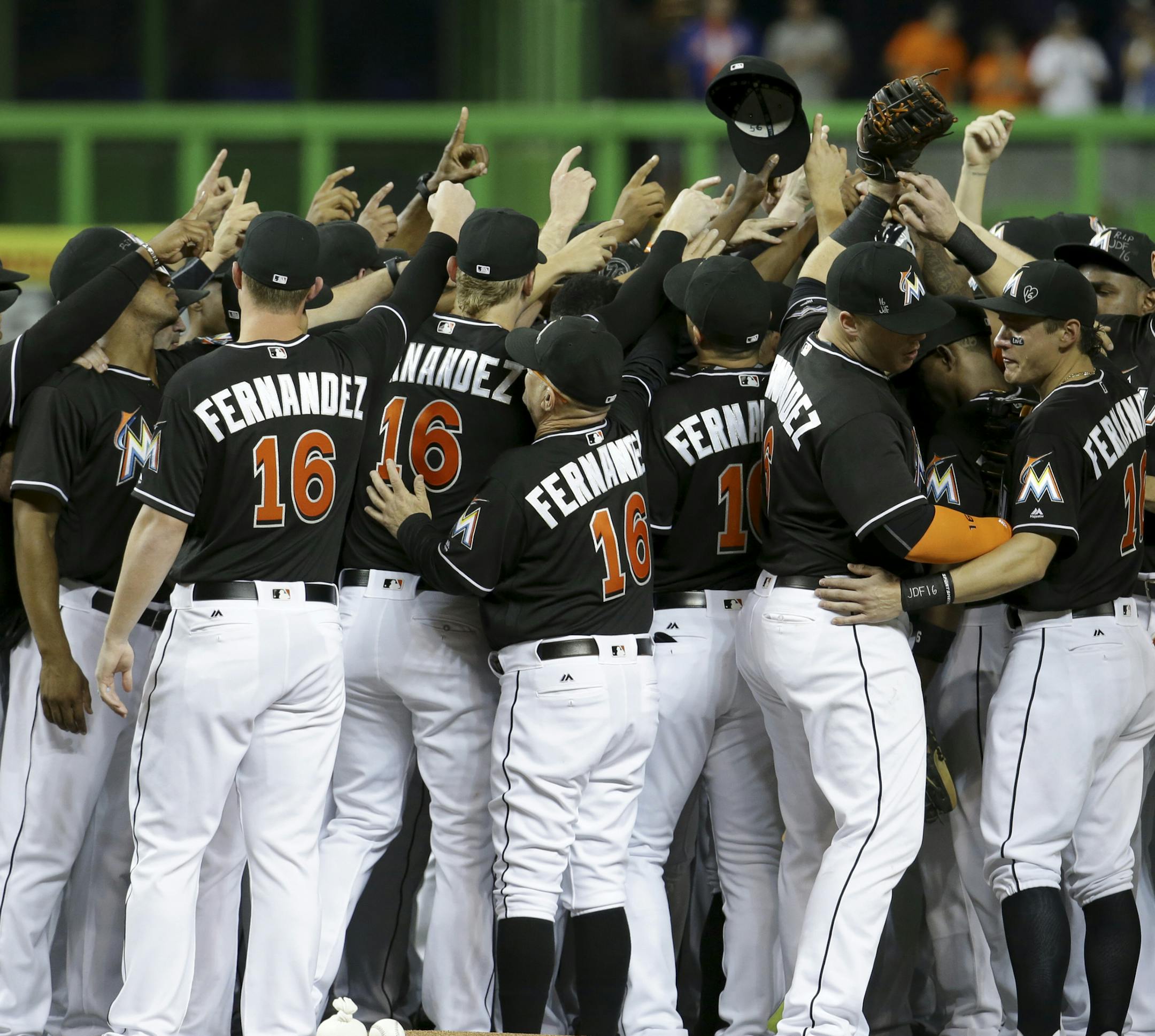 Miami Marlins players wearing a jersey in honor of pitcher Jose Fernandez (16) gather around the pitching mound before a baseball game against the New York Mets, Monday, Sept. 26, 2016, in Miami. Fernandez died in a boating accident Sunday. (AP Photo/Lynne Sladky)