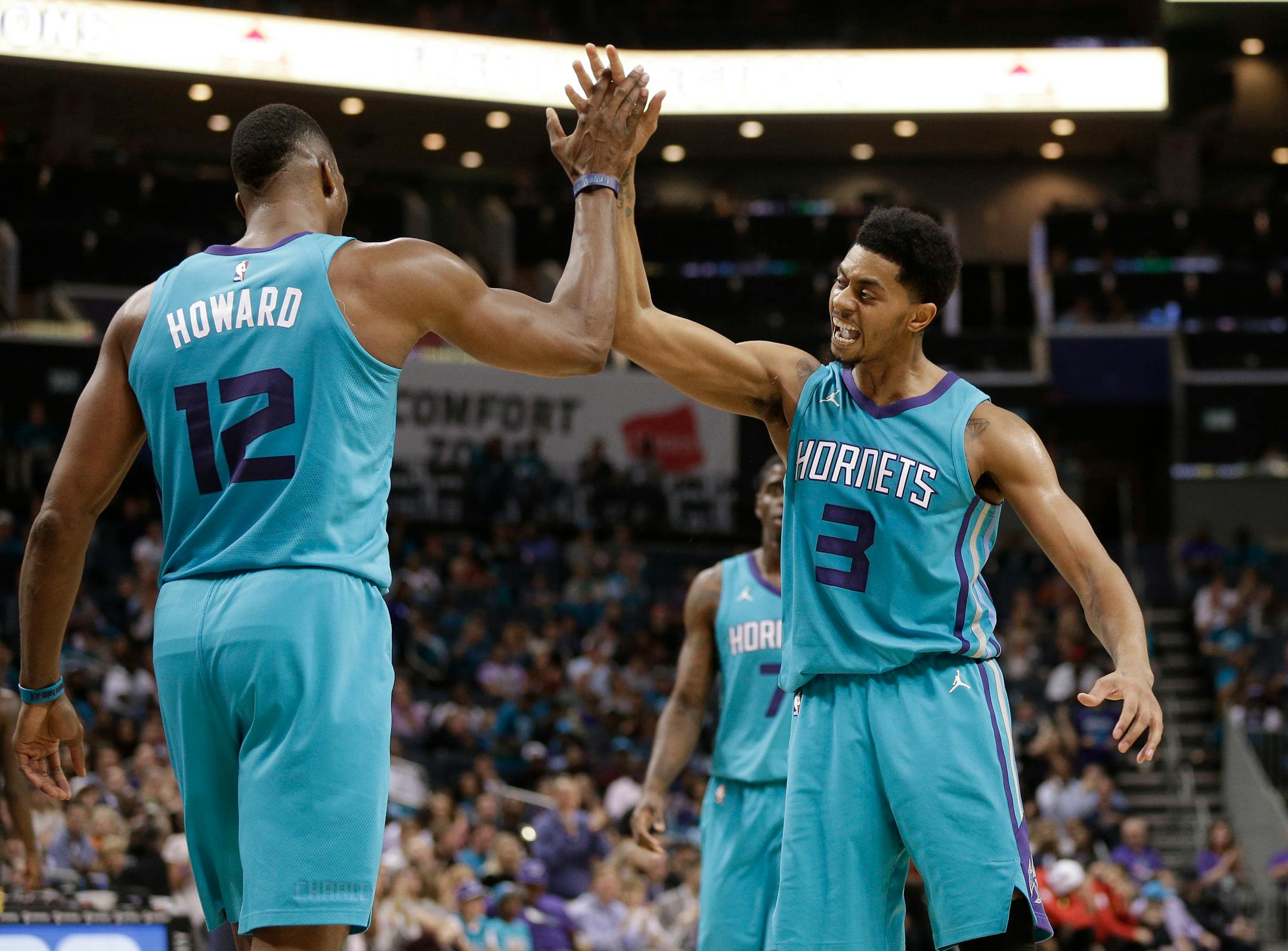 Charlotte Hornets' Jeremy Lamb (3) celebrates with Dwight Howard (12) after a basket against the Atlanta Hawks during the second half of an NBA basketball game in Charlotte, N.C., Friday, Oct. 20, 2017. (AP Photo/Chuck Burton)